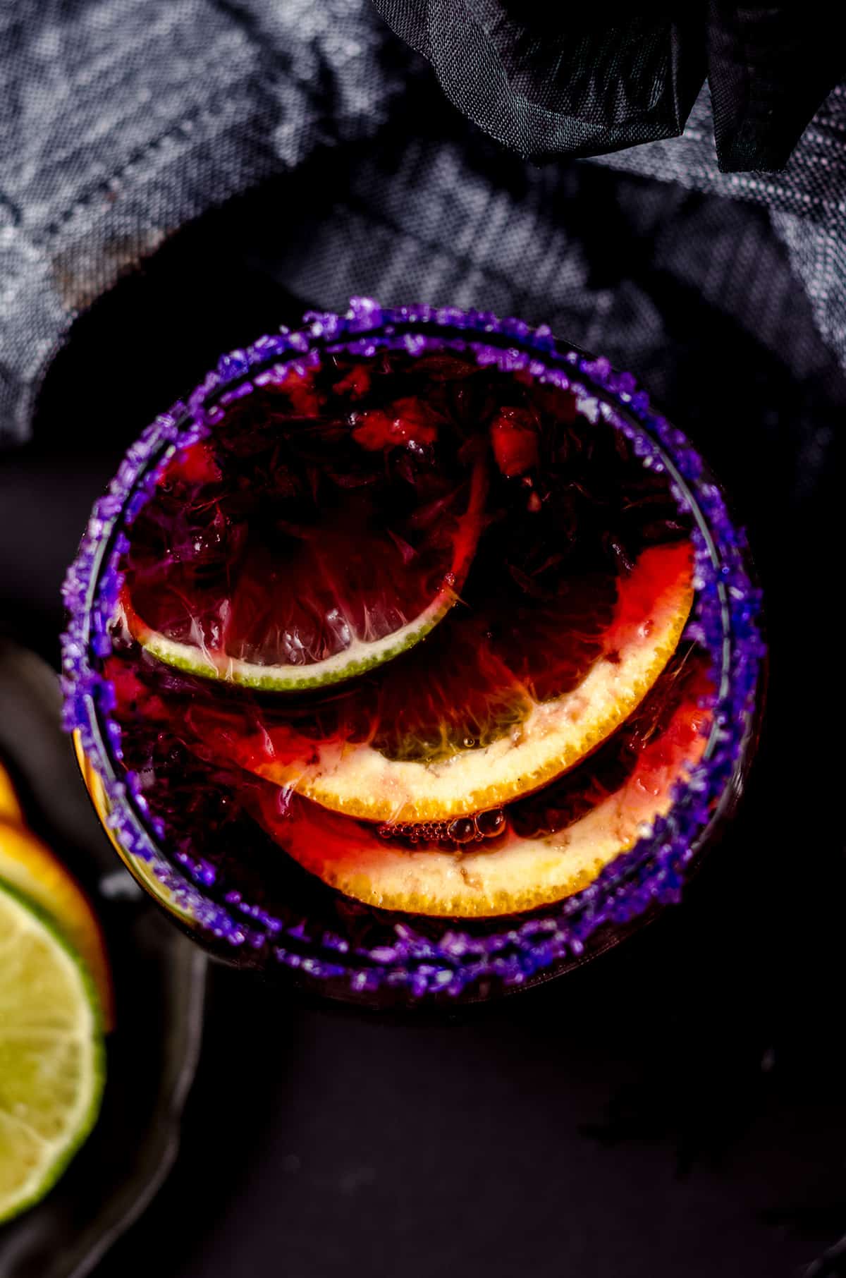 aerial photo of glass of halloween sangria with halloween decor around it