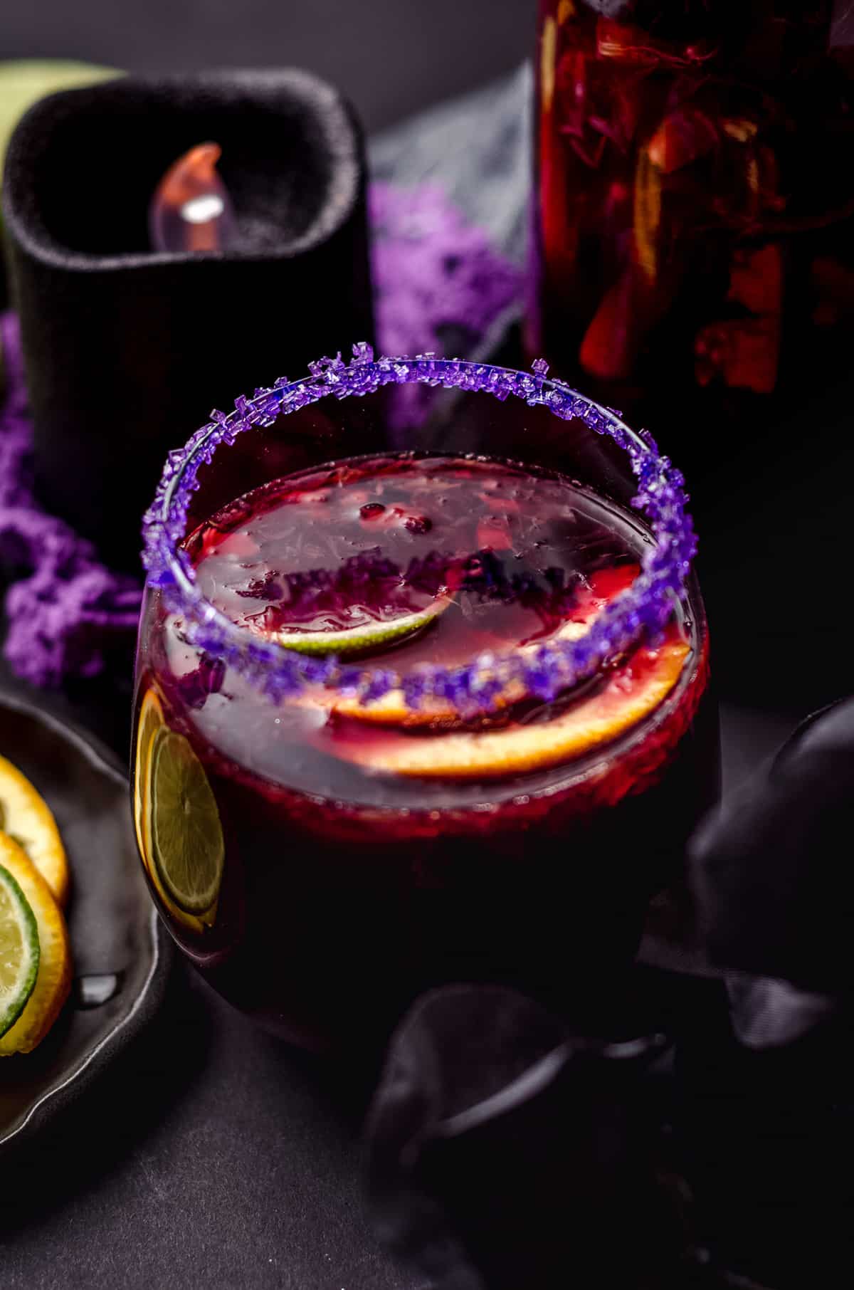 glass of halloween sangria with halloween decor around it