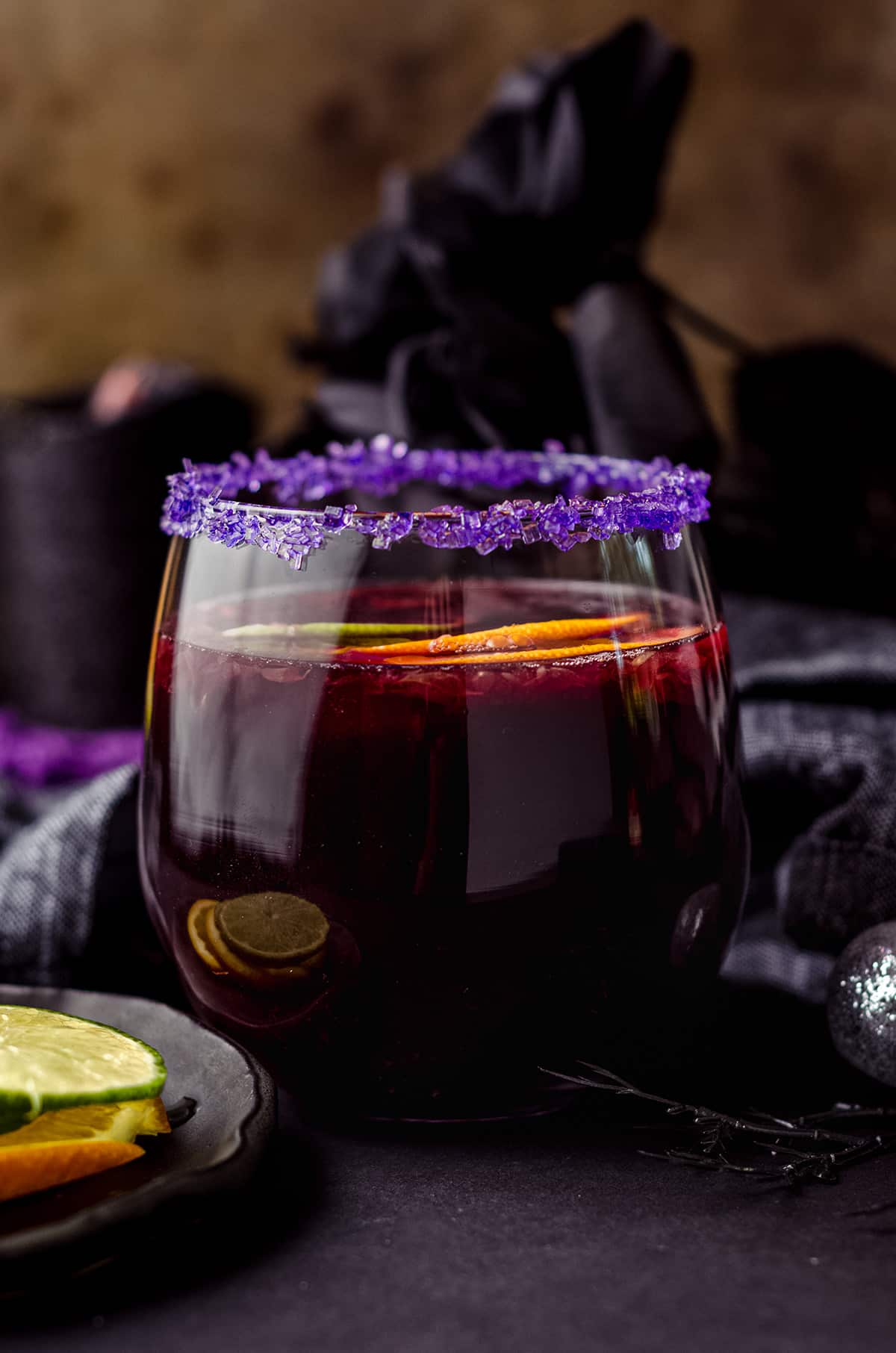 glass of halloween sangria with halloween decor around it