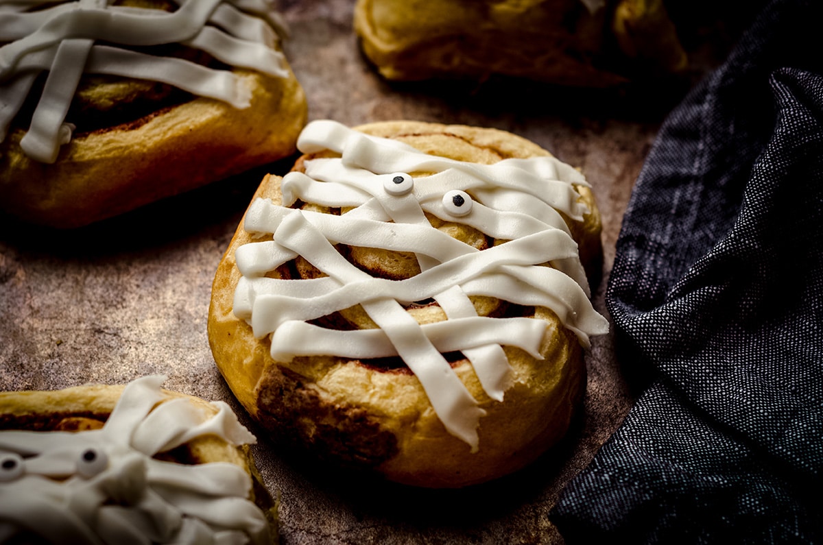 cinnamon roll mummies on a baking sheet