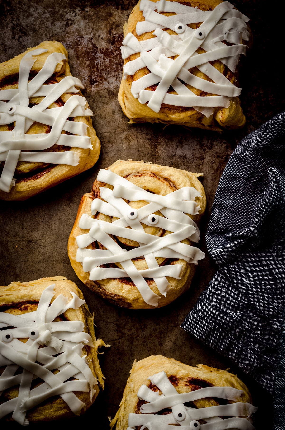 aerial photo of cinnamon roll mummies on a baking sheet