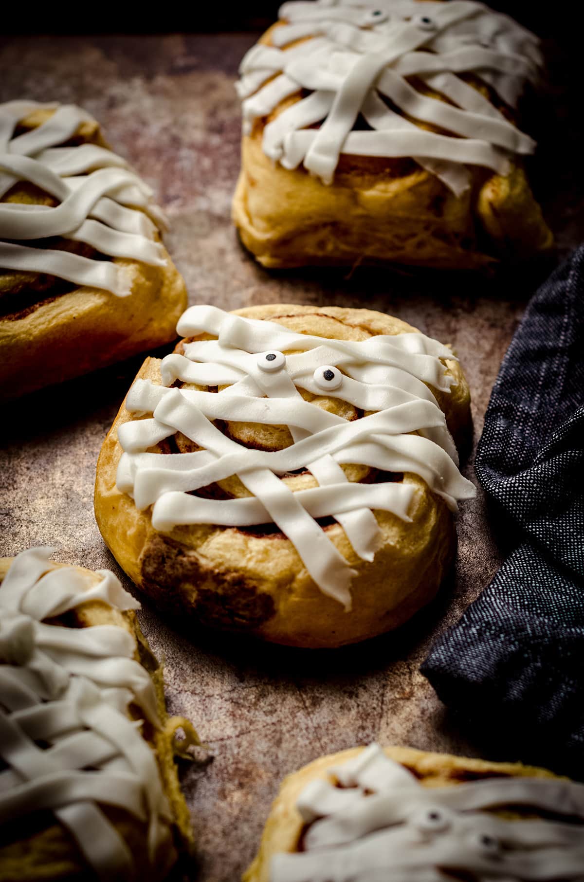 cinnamon roll mummies on a baking sheet