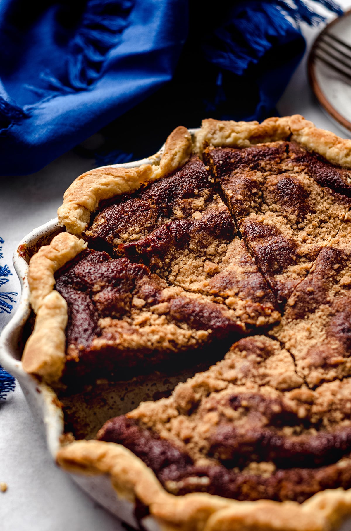 A close up of a shoofly pie with a piece missing.