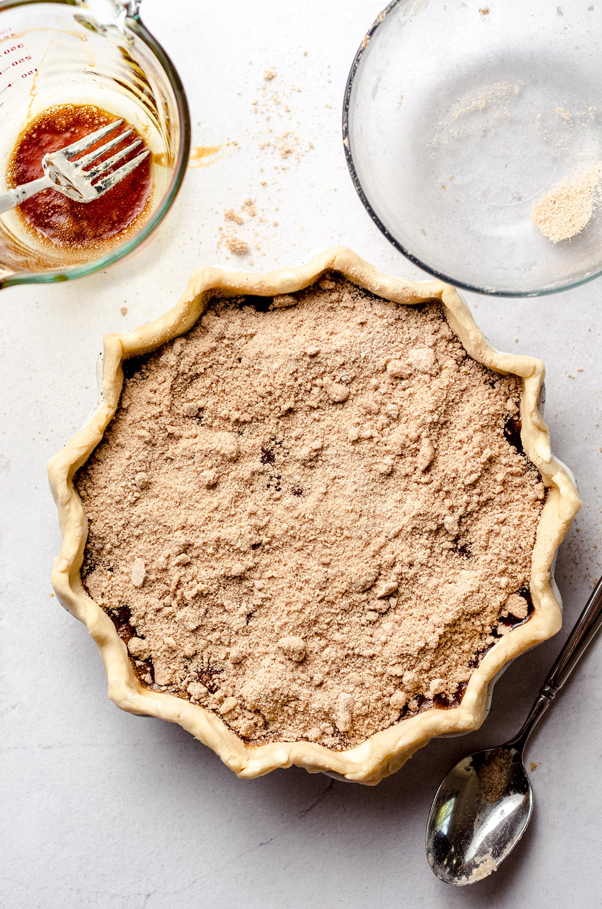 An overhead view of a pie topped with a crumb mixture.