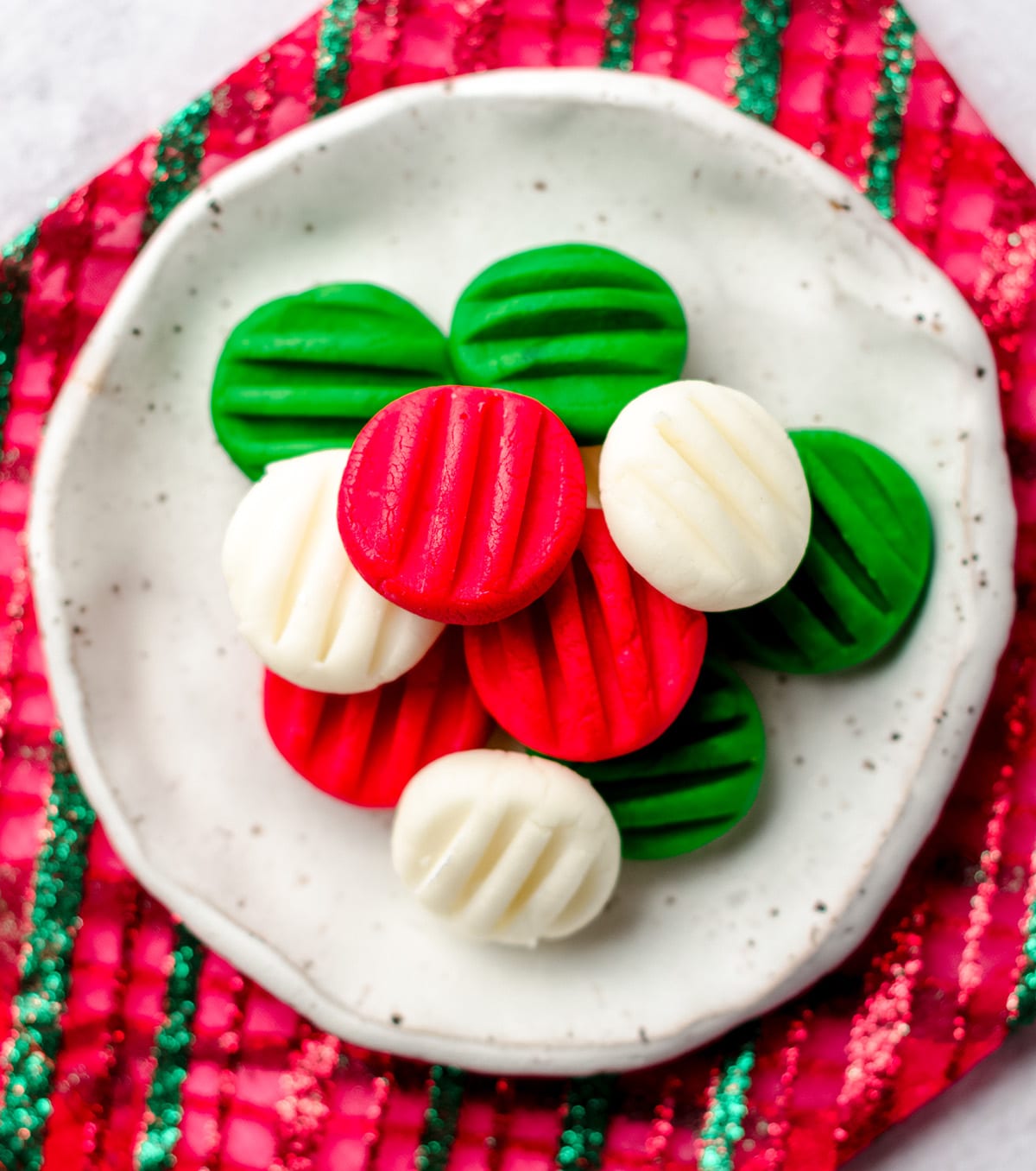 A plate with red, green and white cream cheese mints for Christmas.