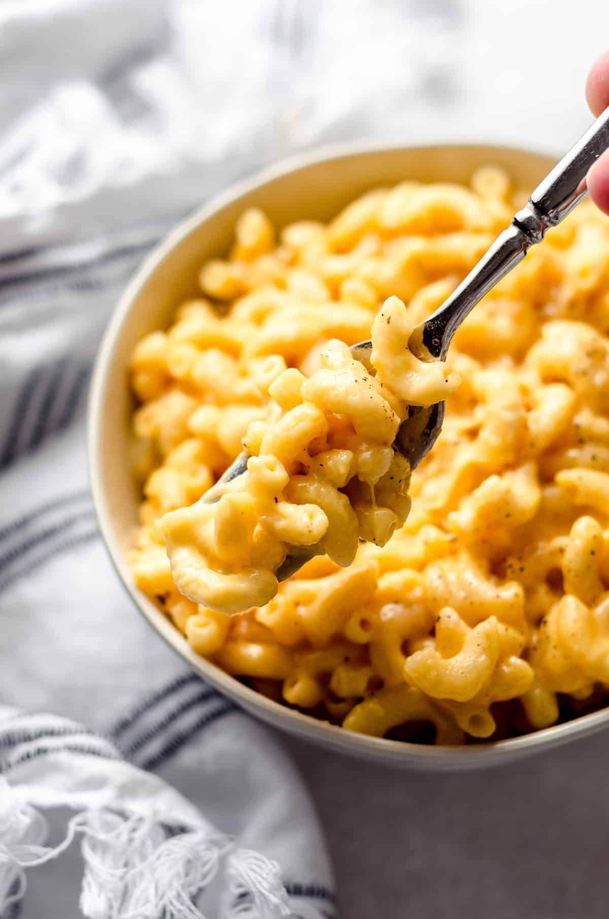 A bowl of macaroni and cheese with a fork in it.