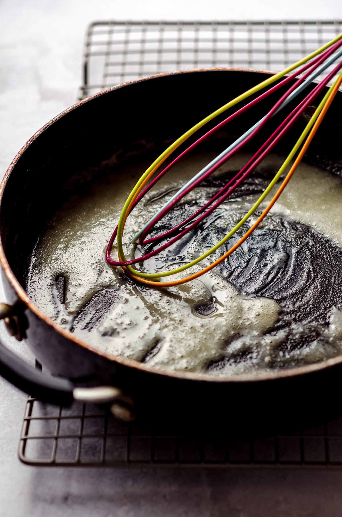 Whisking together butter and flour in a saucepan.