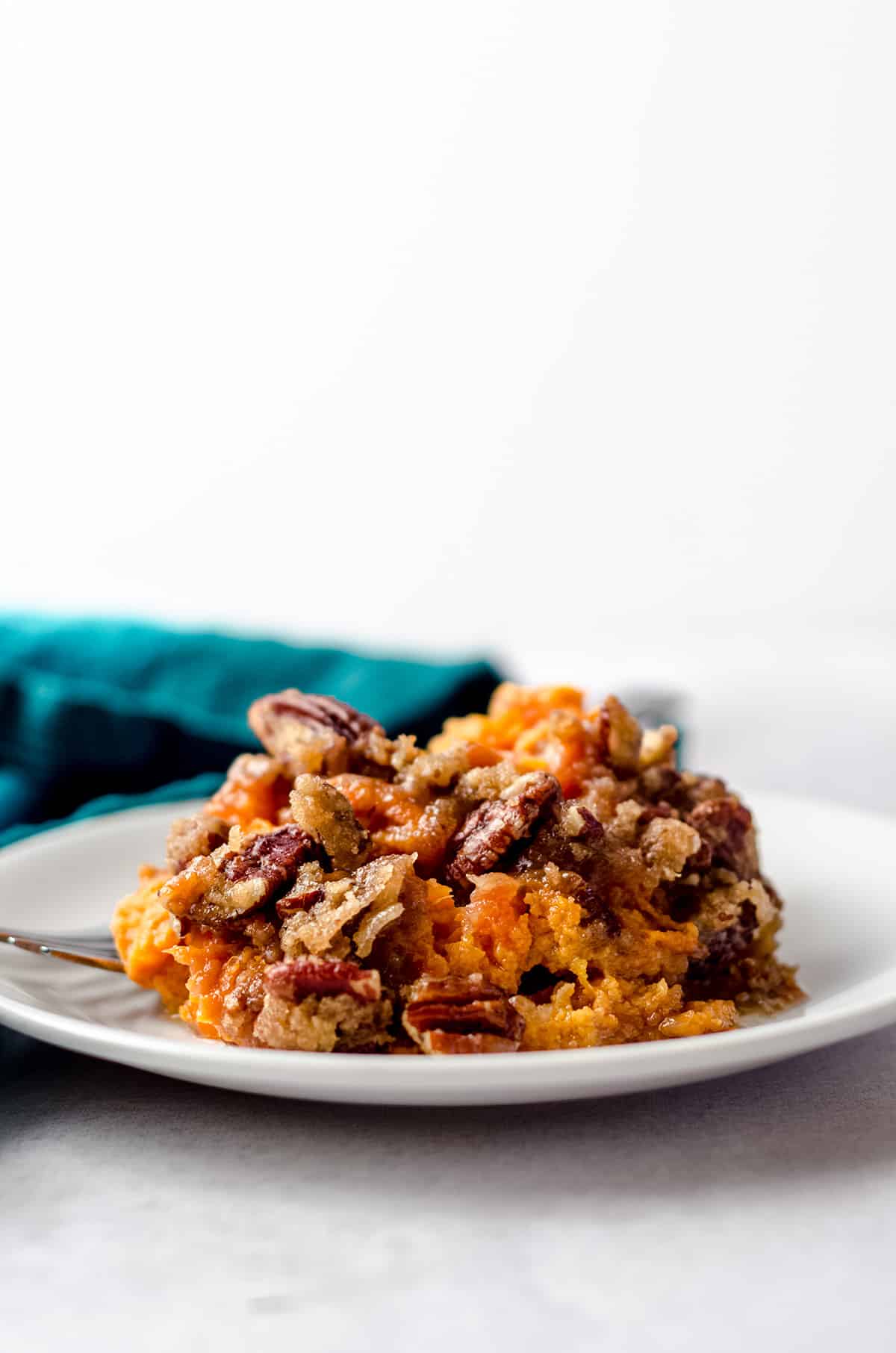 A plate of a sweet potato casserole with a crunchy topping.