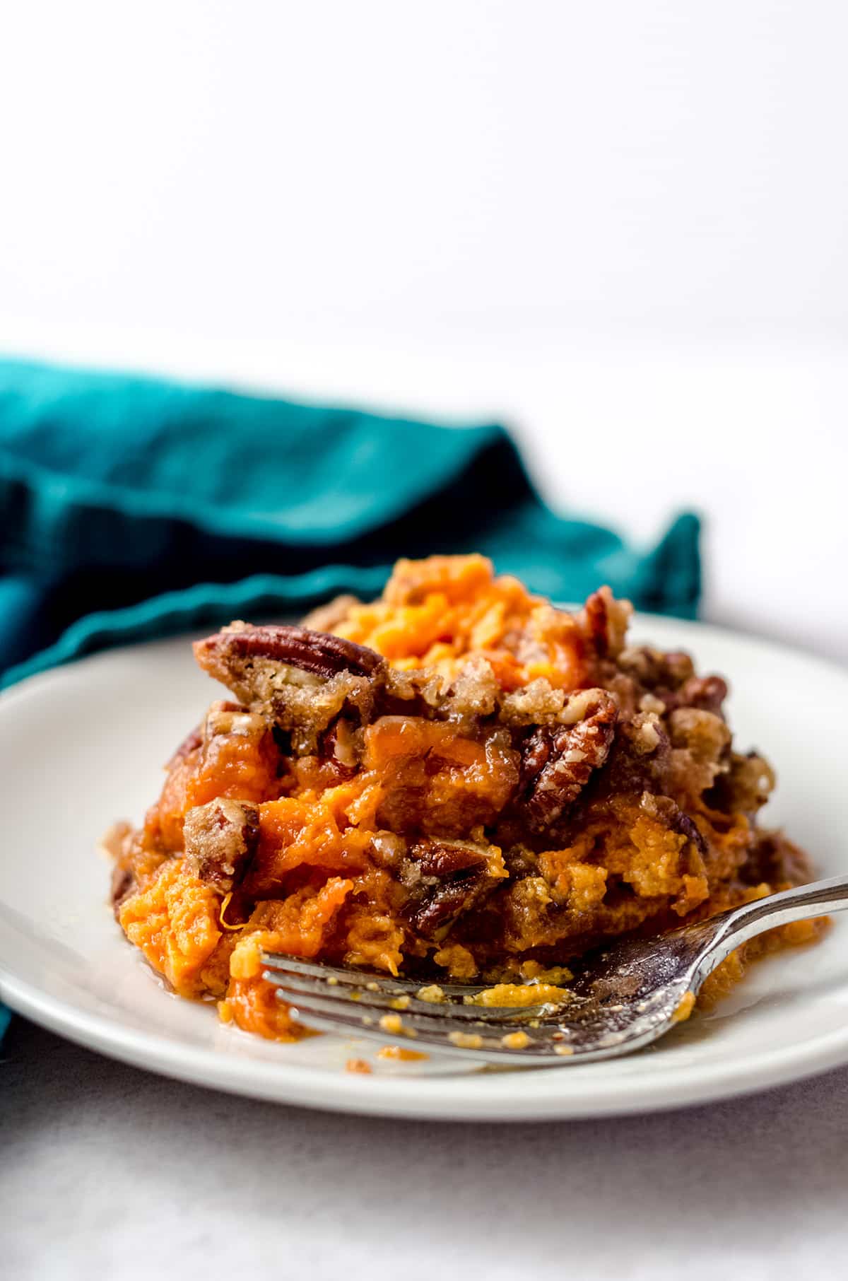 A serving of sweet potato casserole topped with pecans.