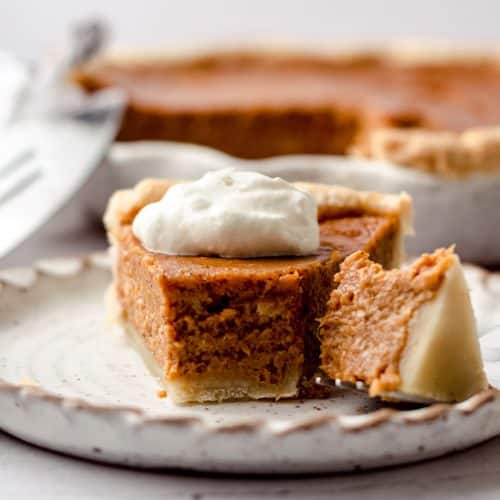 A slice of homemade pie topped with whipped cream.