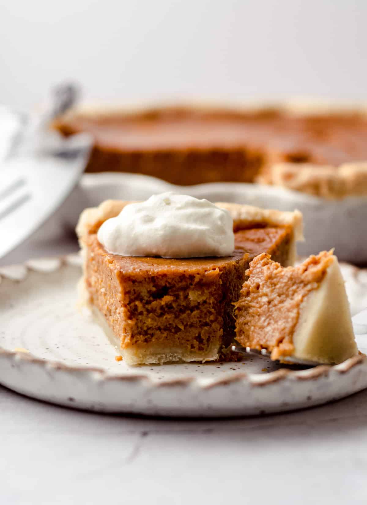 A slice of homemade pie topped with whipped cream.