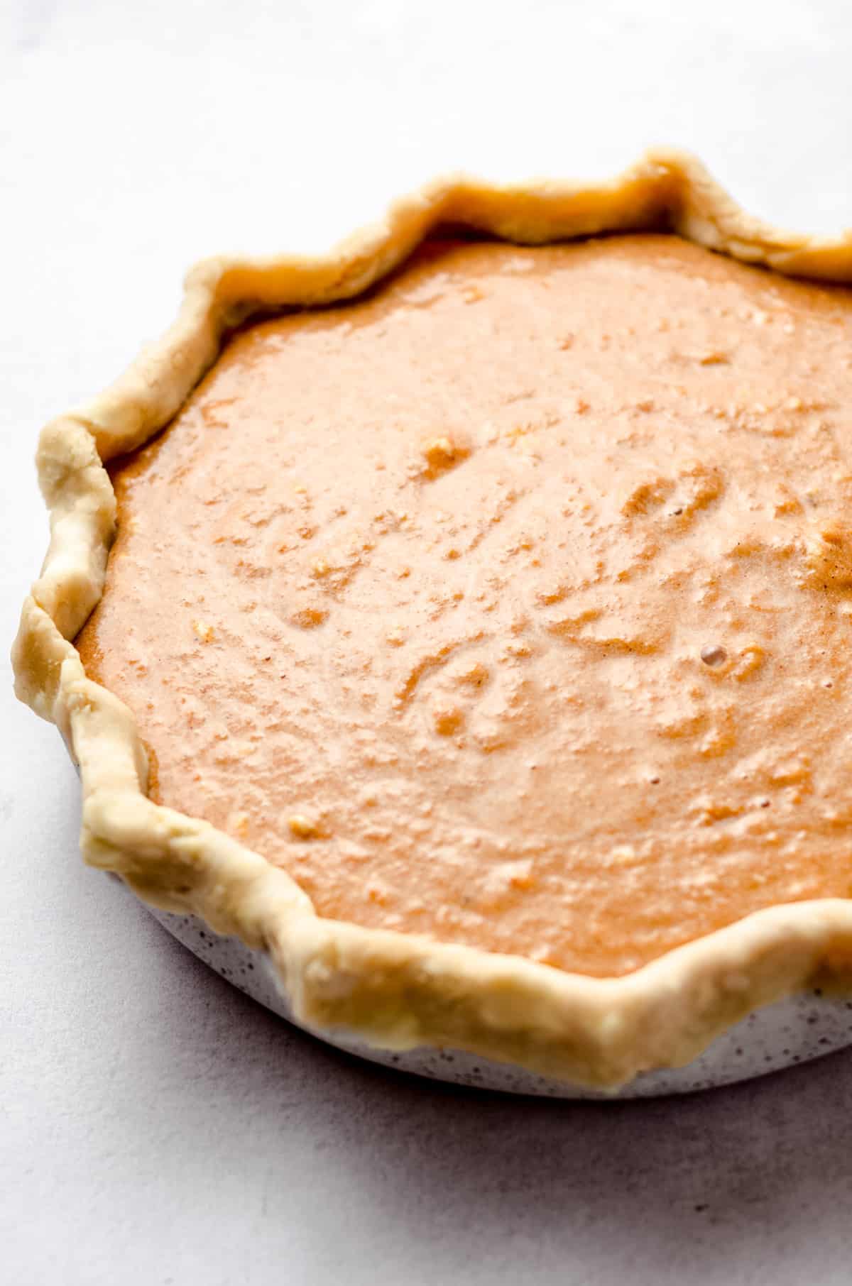 A homemade pie crust filled with a sweet potato filling.