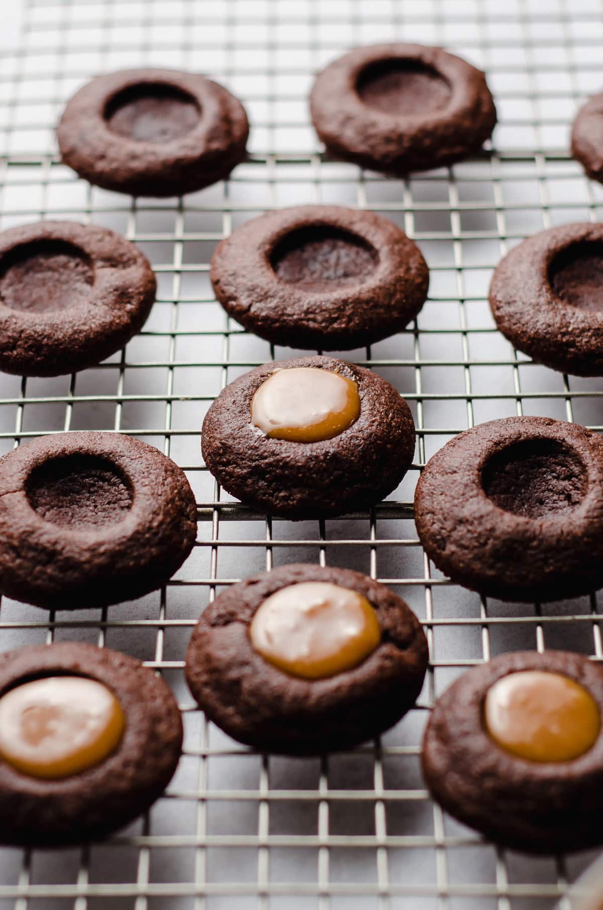 chocolate caramel thumbprint cookies on a cooling rack