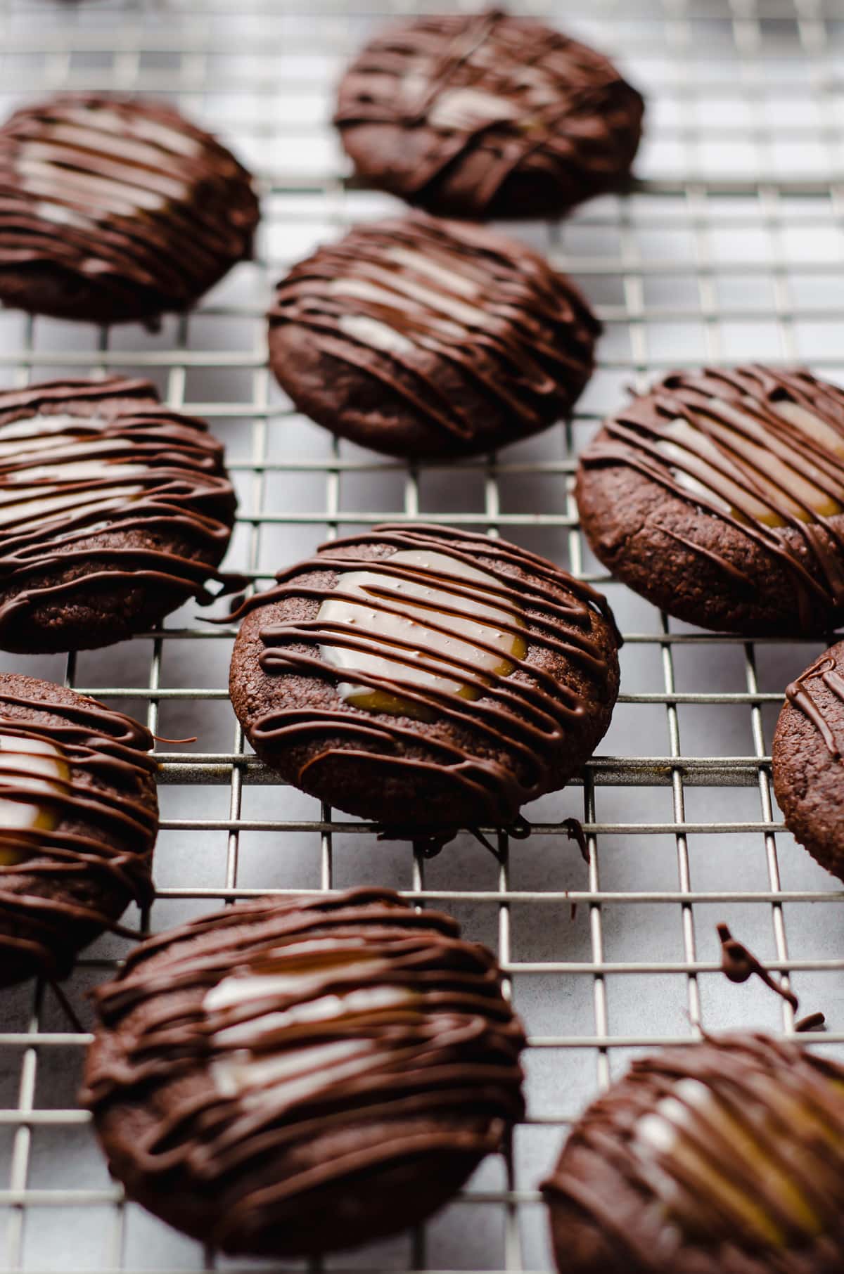 chocolate caramel thumbprint cookies on a cooling rack