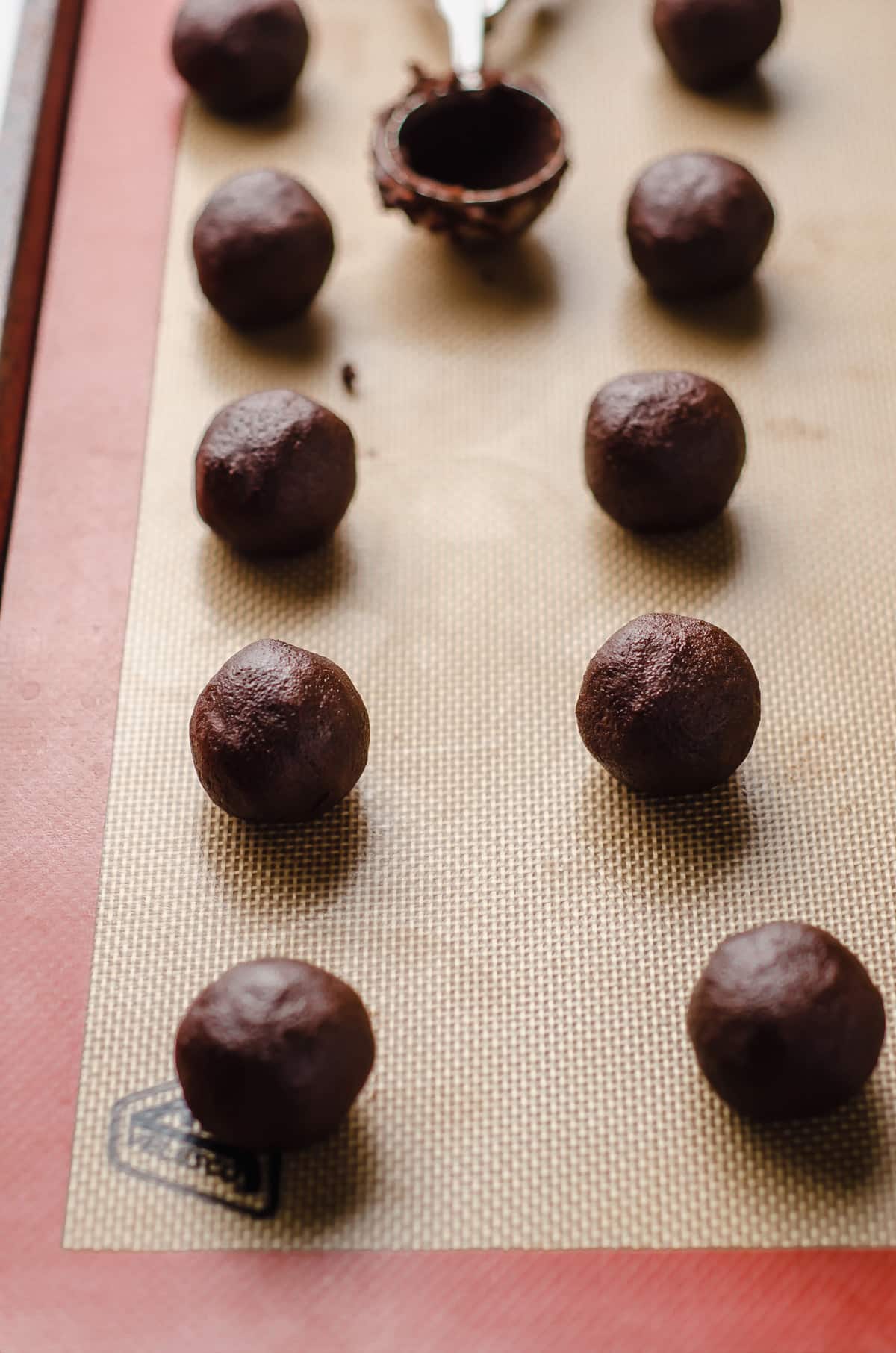 chocolate cookie dough balls on a baking sheet