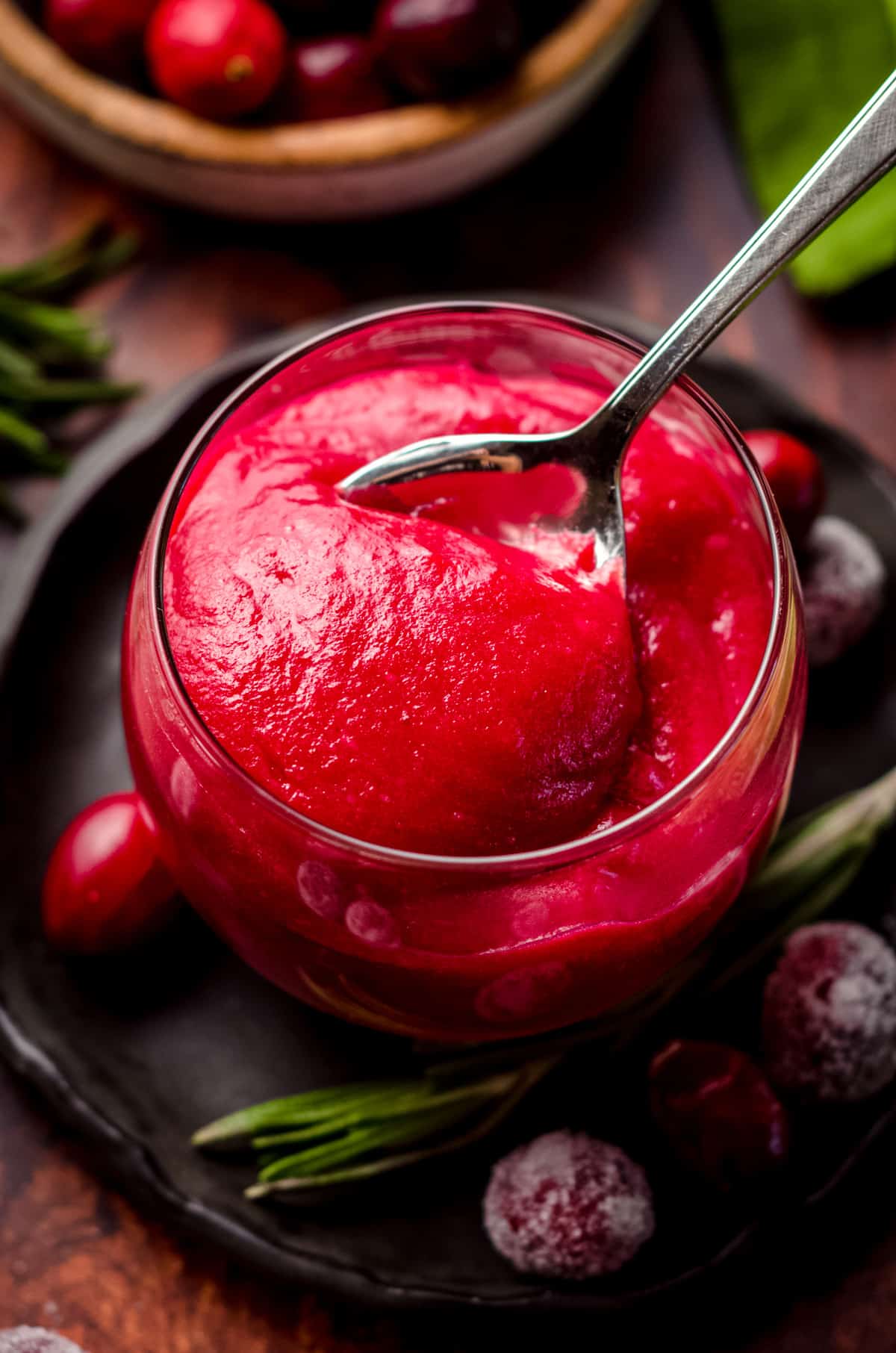 a spoon scooping out cranberry curd from a jar