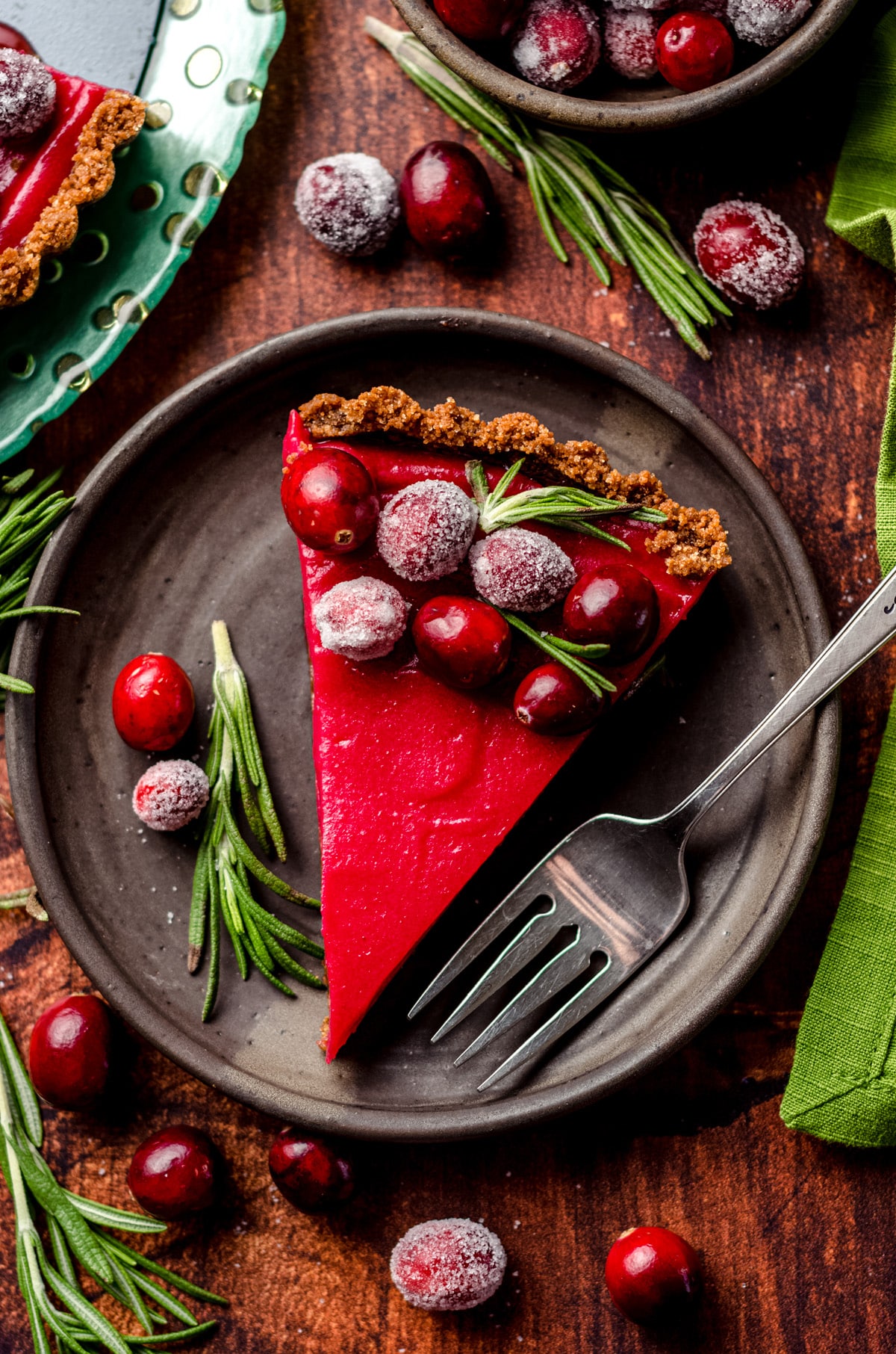 A slice of cranberry tart with sugared cranberries.