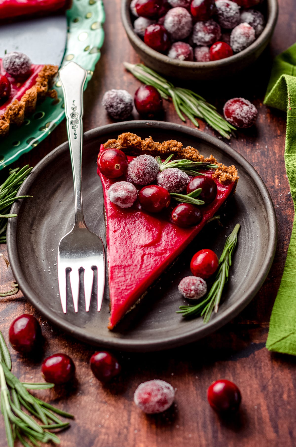 A slice of cranberry tart garnished with sugared cranberries.