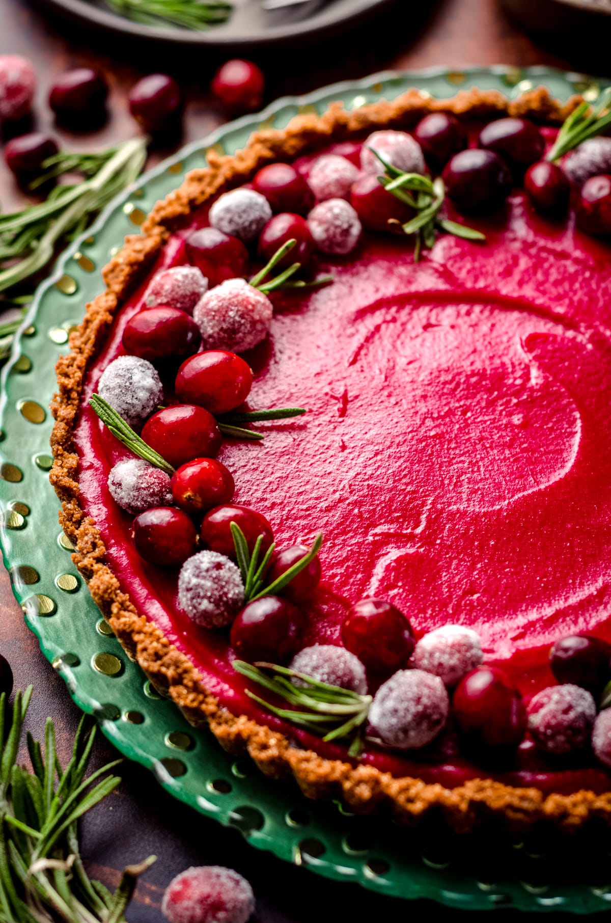 A tart filled with cranberry curd and decorated with sugared cranberries.