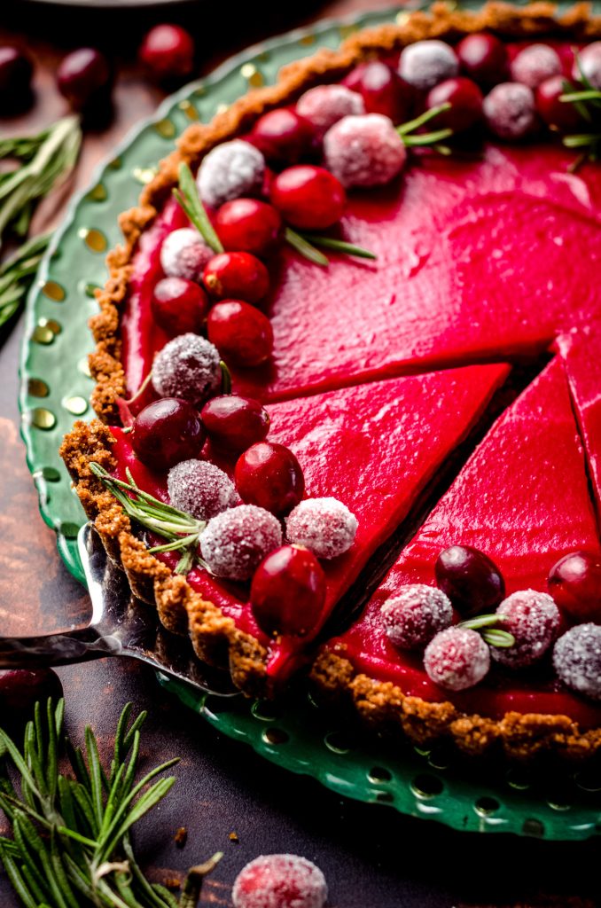 A slice being removed from a cranberry tart.