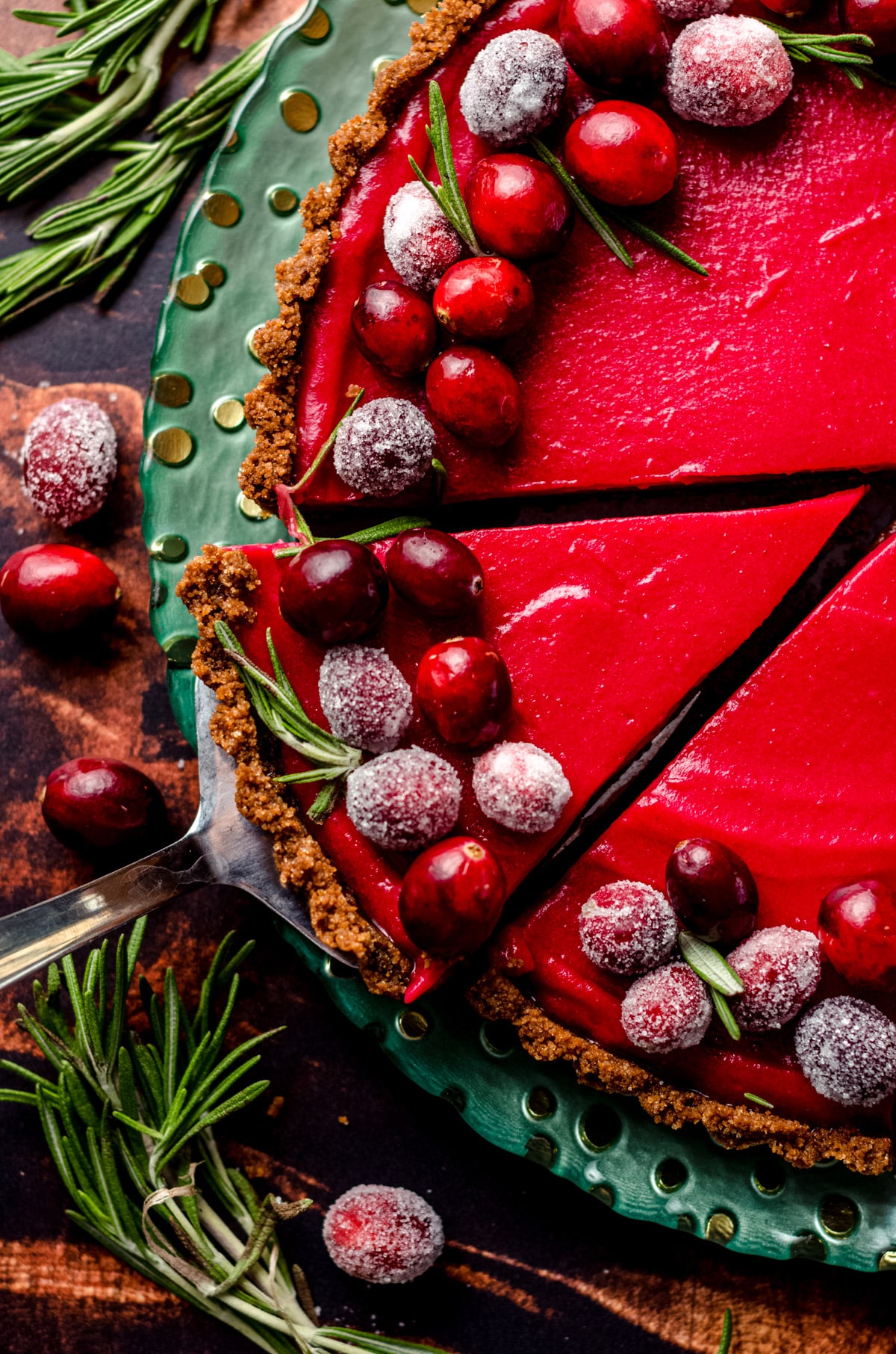A cranberry tart with a single slice cut out.