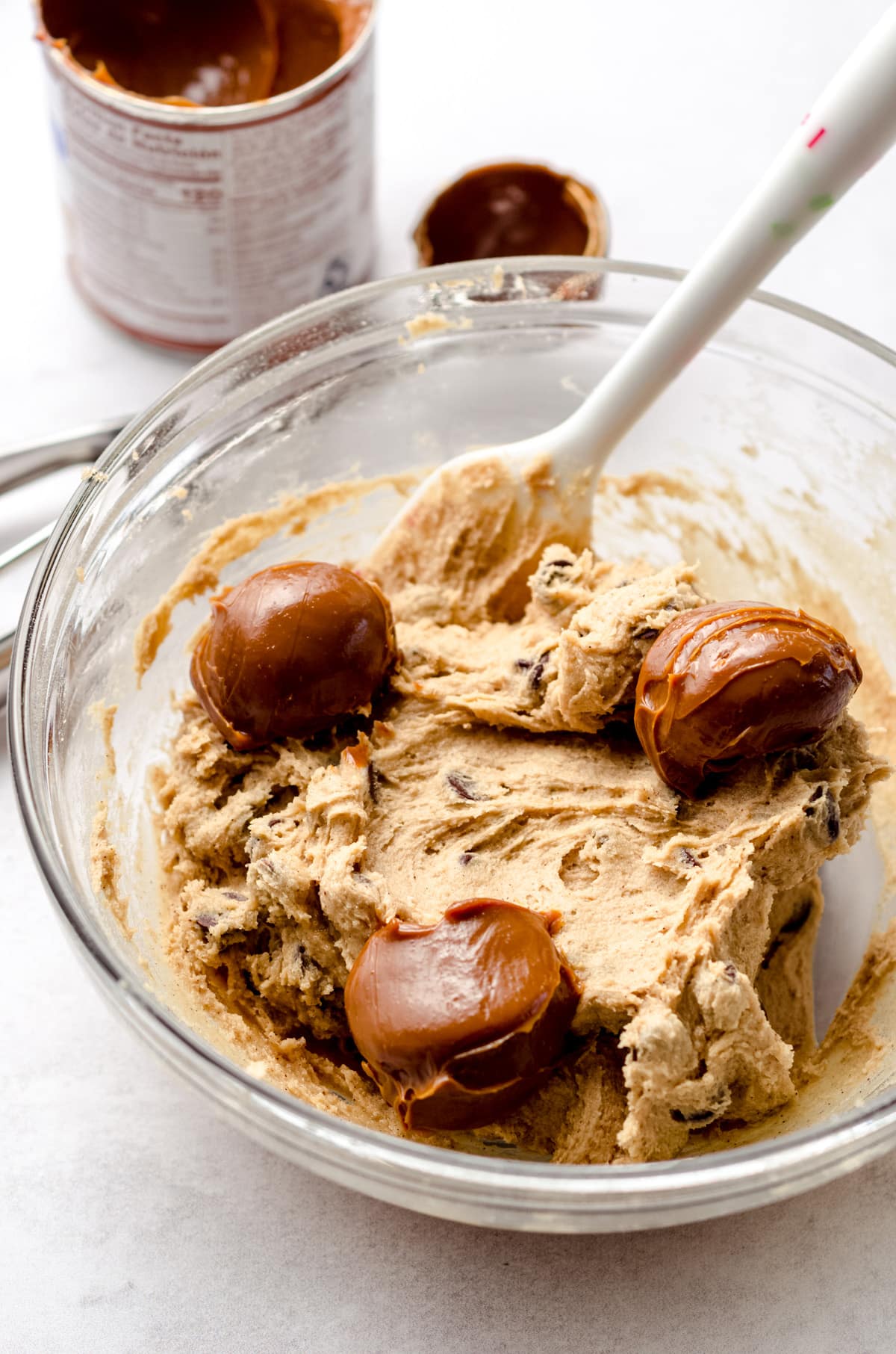 A base cookie dough with 3 large dollops of dulce de leche spread out.