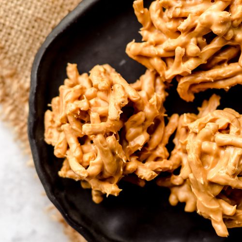 A black plate with three haystack cookies.