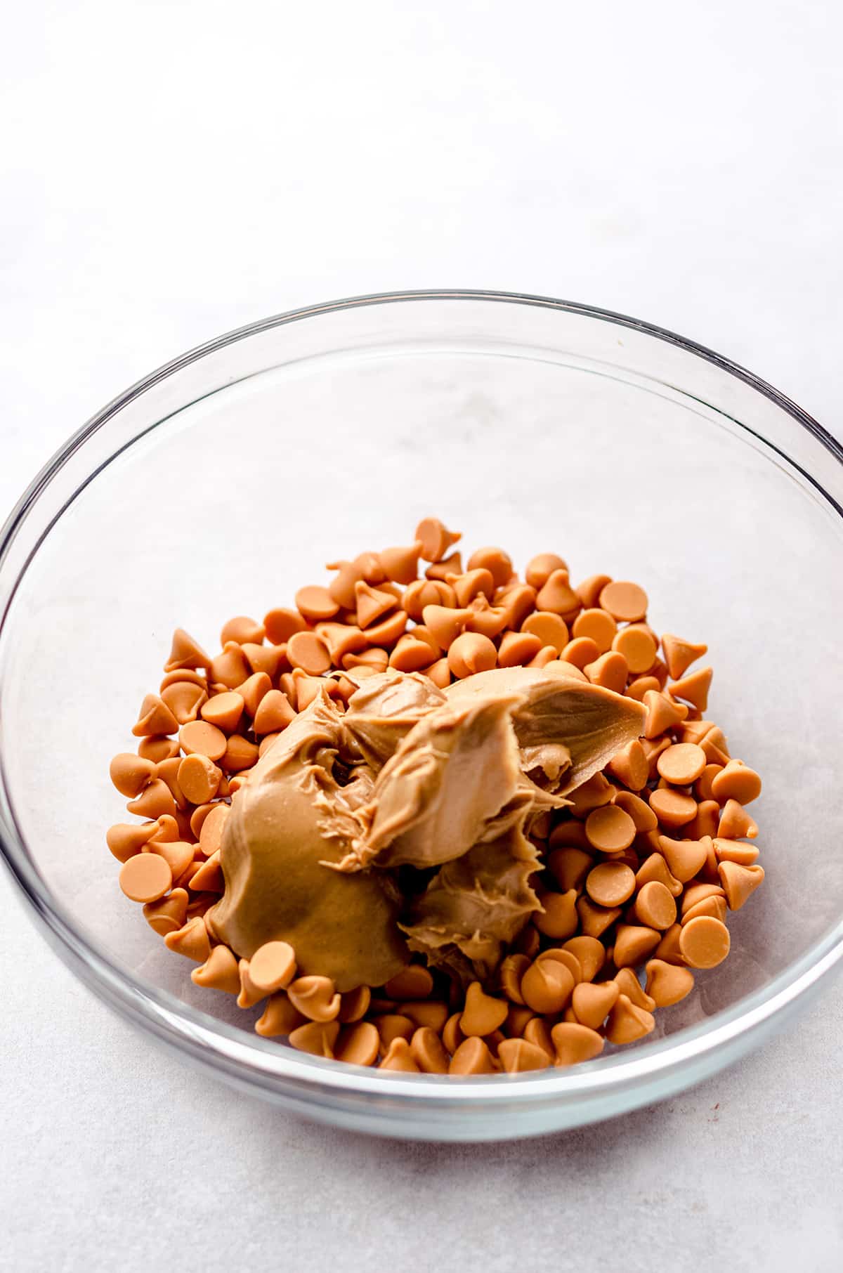 A bowl with butterscotch chips and peanut butter.