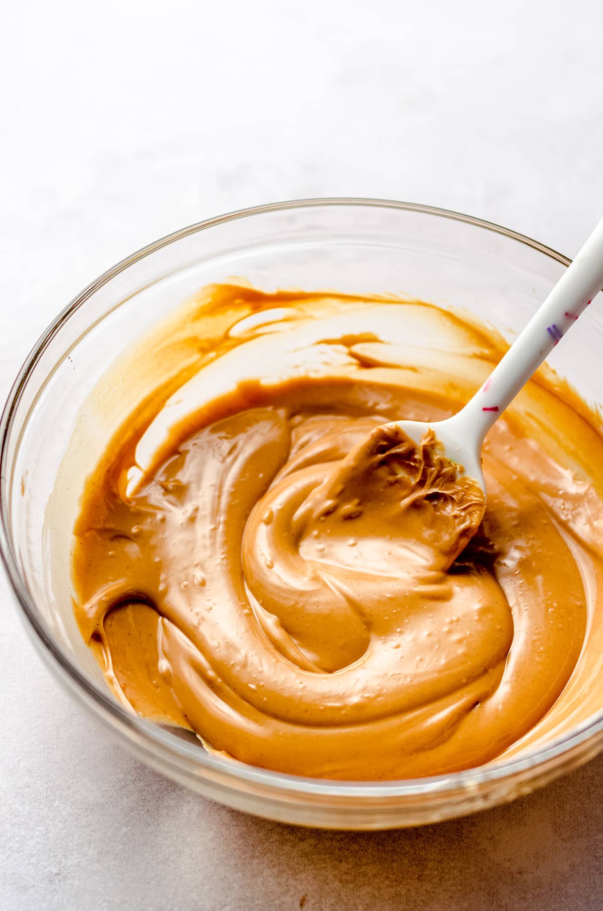 Stirring melted butterscotch chips and peanut butter together.