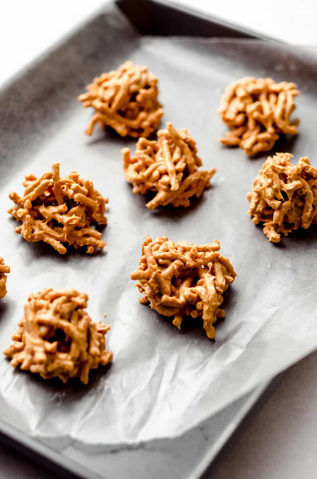 A baking sheet with mounts of butterscotch haystack cookies.