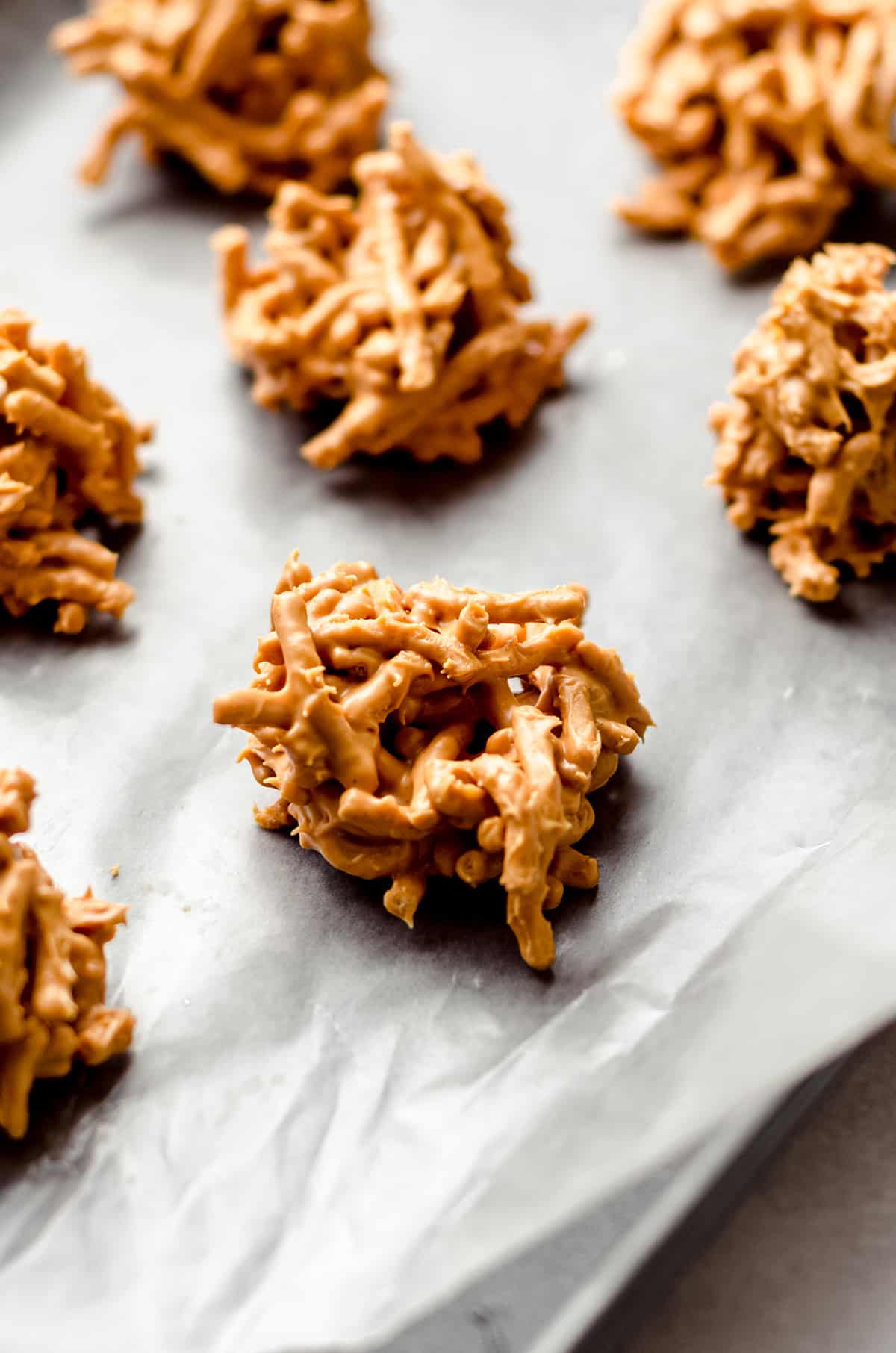 A baking sheet with mounds of chow mein cookies on it.