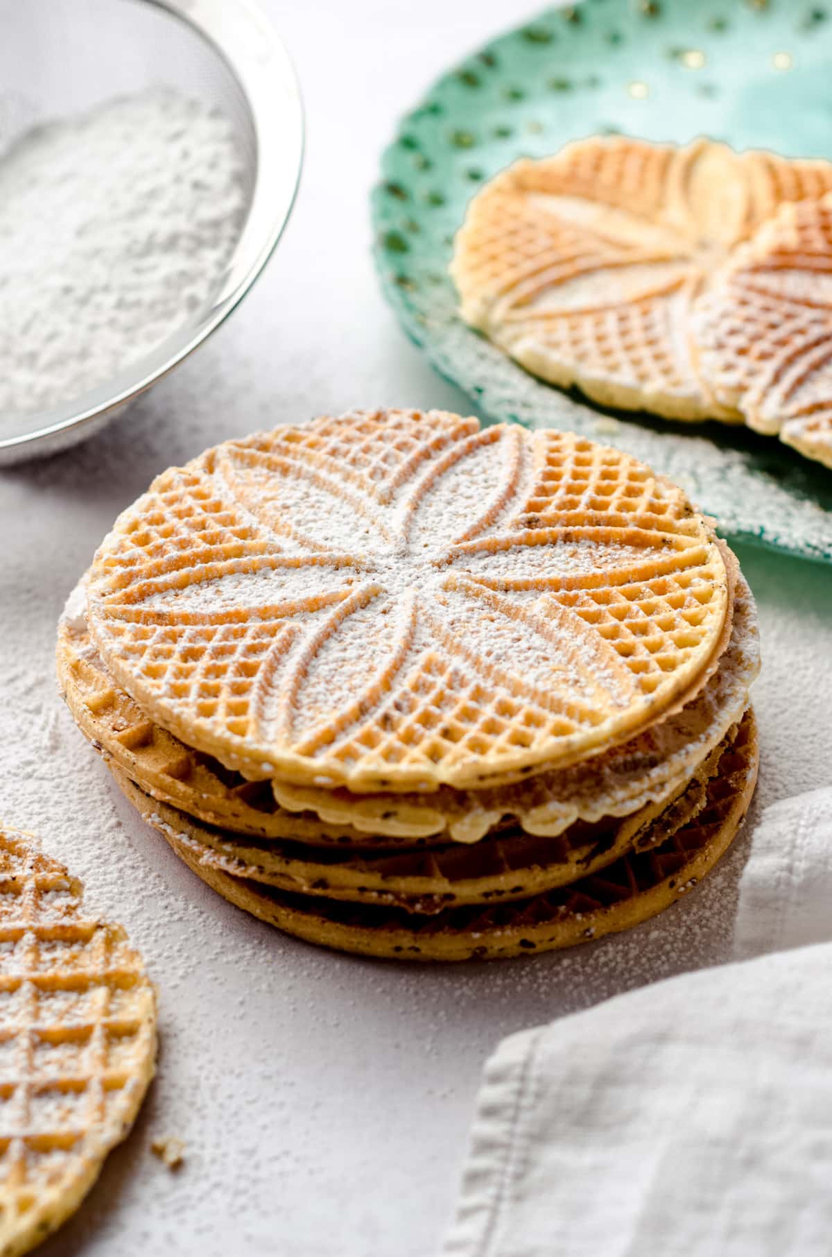 A stack of Italian cookies dusted with powdered sugar.