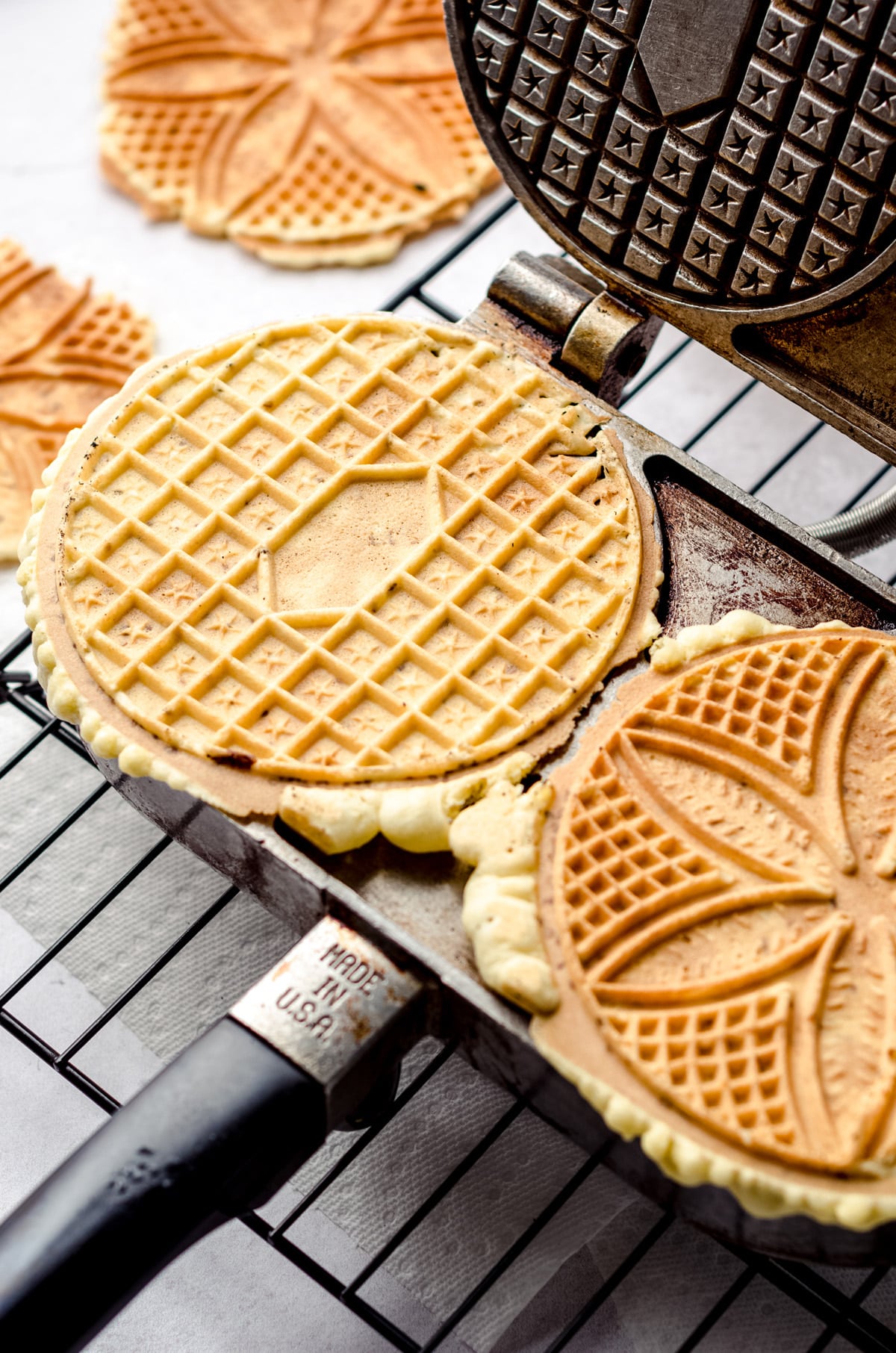 Using a pizzelle iron to make cookies.