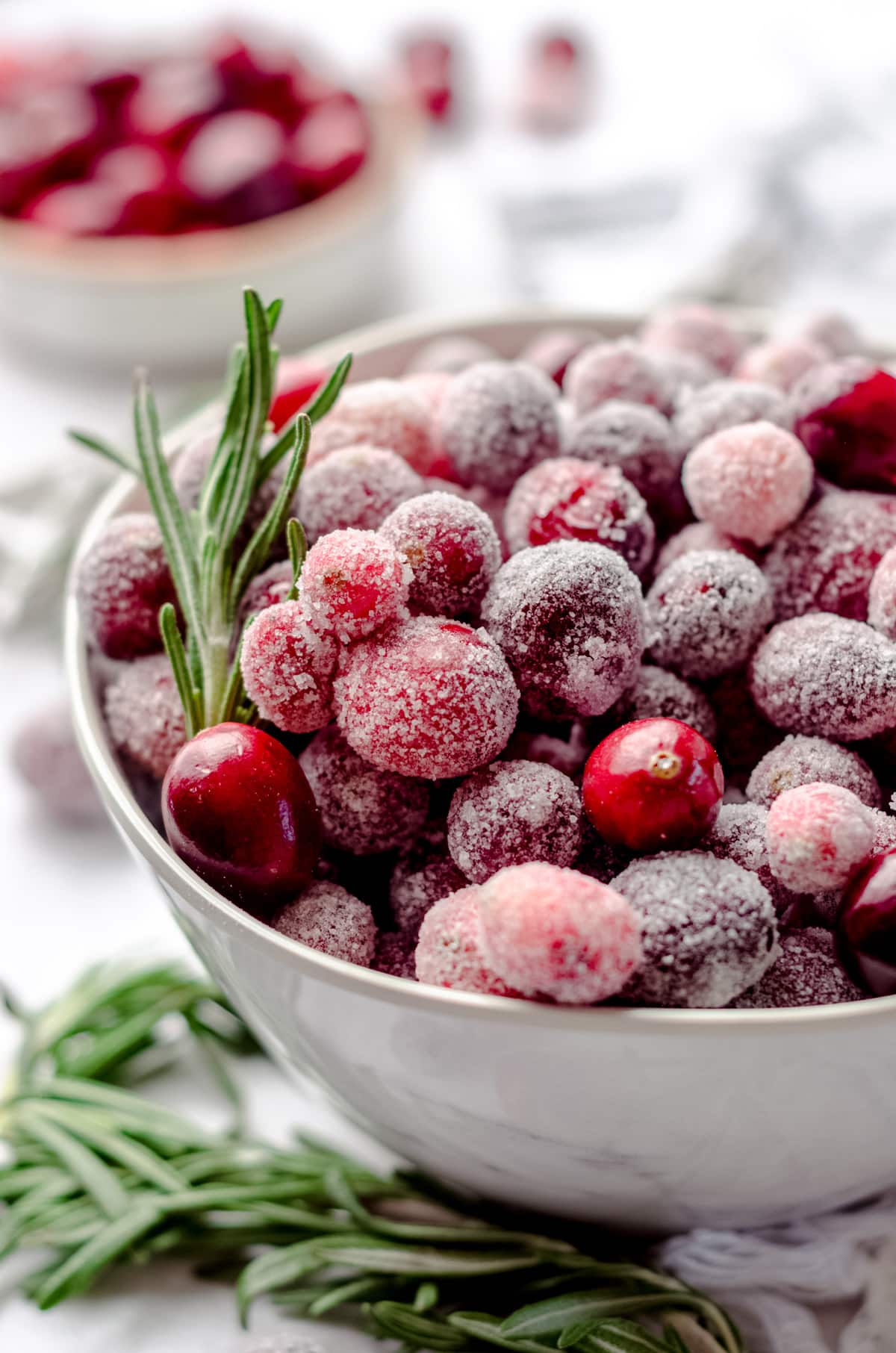 bowl of sugared cranberries with rosemary sprigs