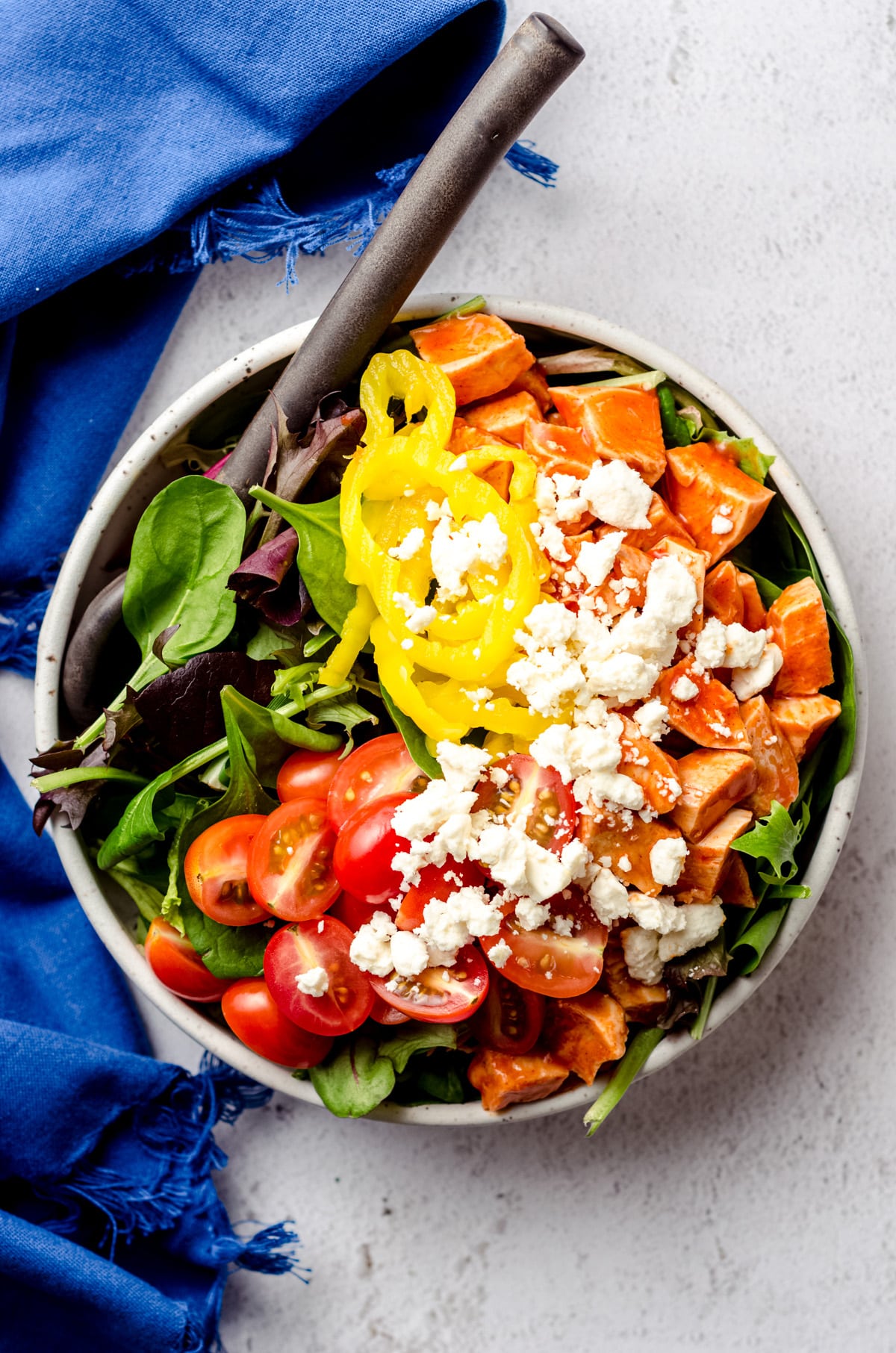 Aerial photo of buffalo blue salad prepared in a bowl with a large serving spoon.