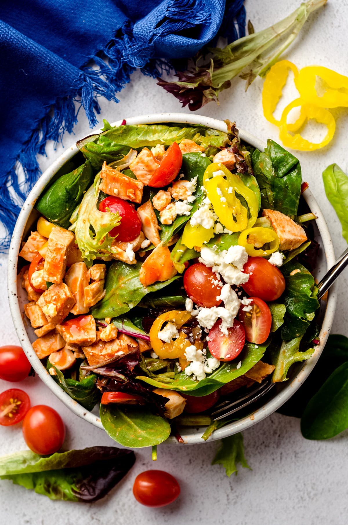 Aerial photo of buffalo blue salad prepared in a large bowl with a fork.