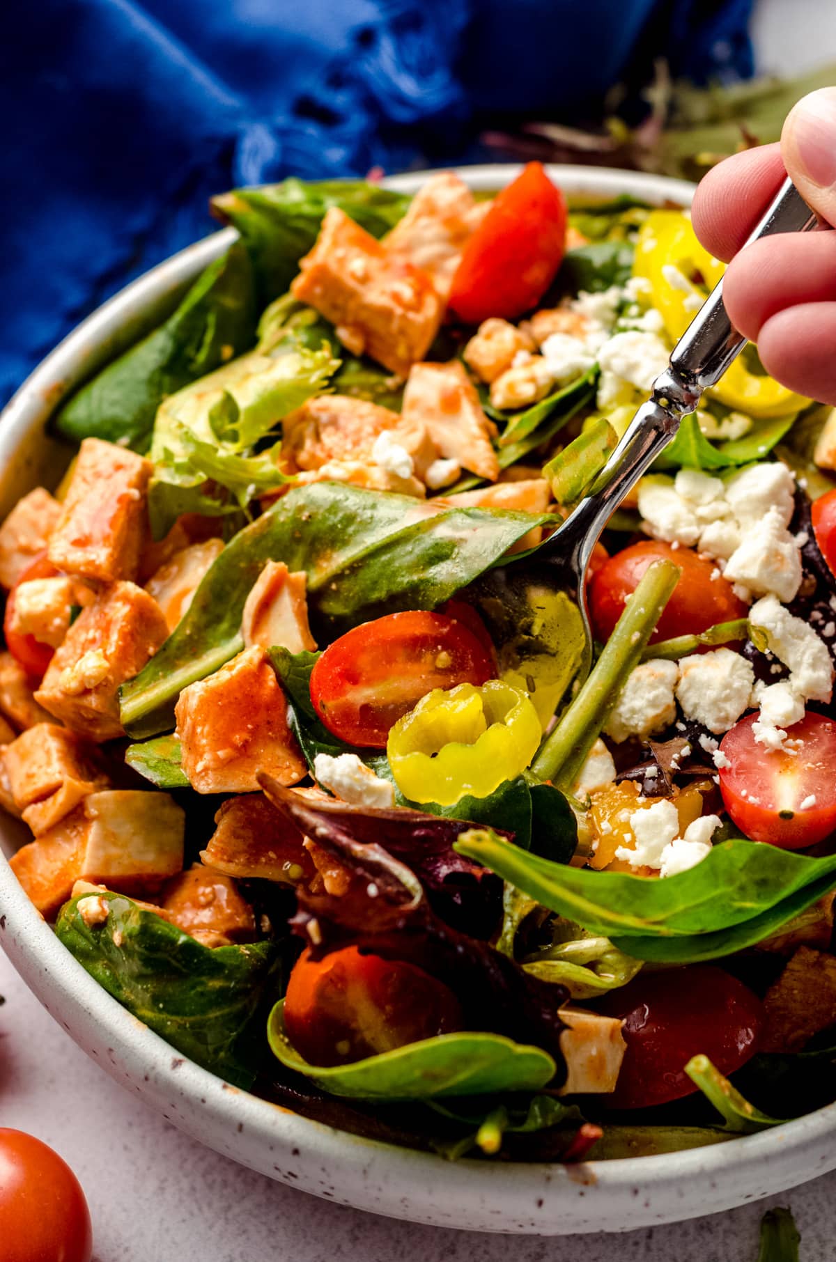 A fork digging into a bowl of buffalo blue salad.