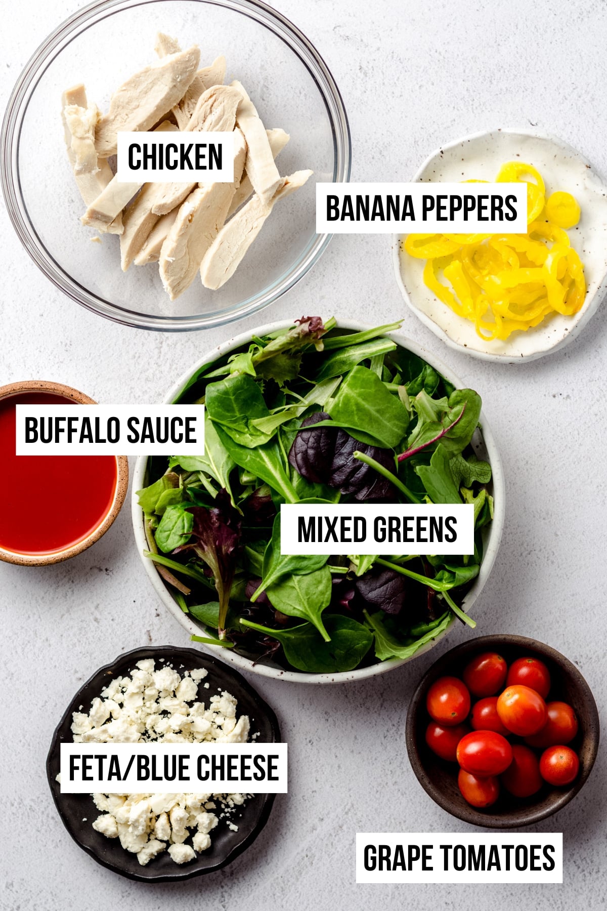 An aerial photo of ingredients to make buffalo blue salad with labels on each ingredient.