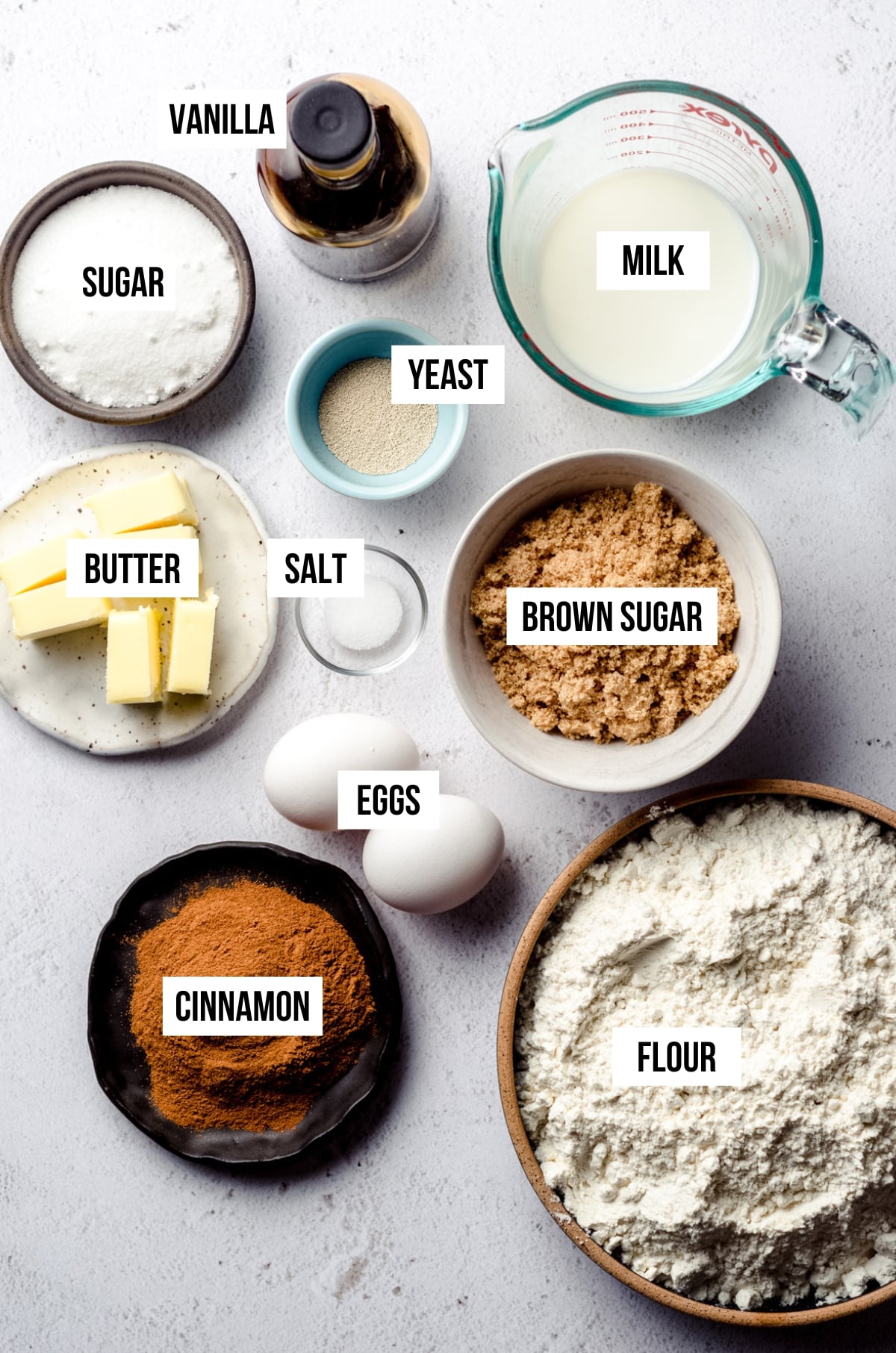 An aerial photo of cinnamon roll ingredients with labels on each ingredient.