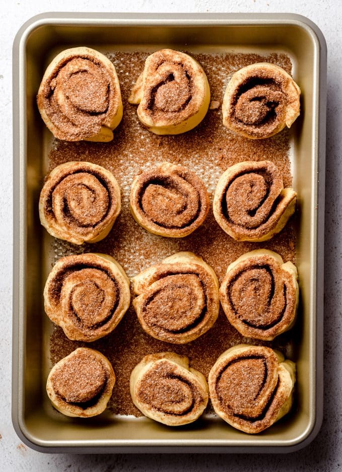 Aerial photo of unbaked cinnamon rolls in a baking pan.