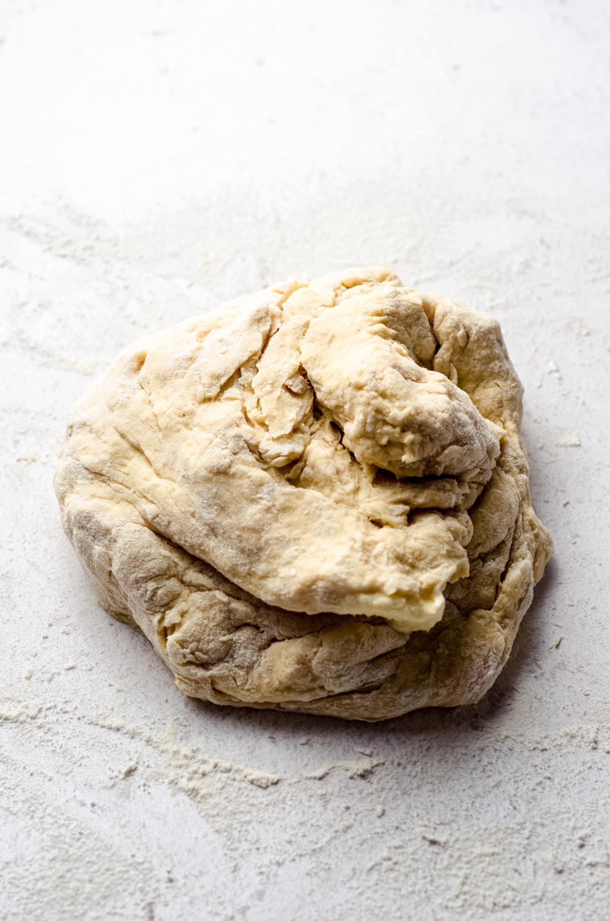 Enriched yeast dough on a white surface.