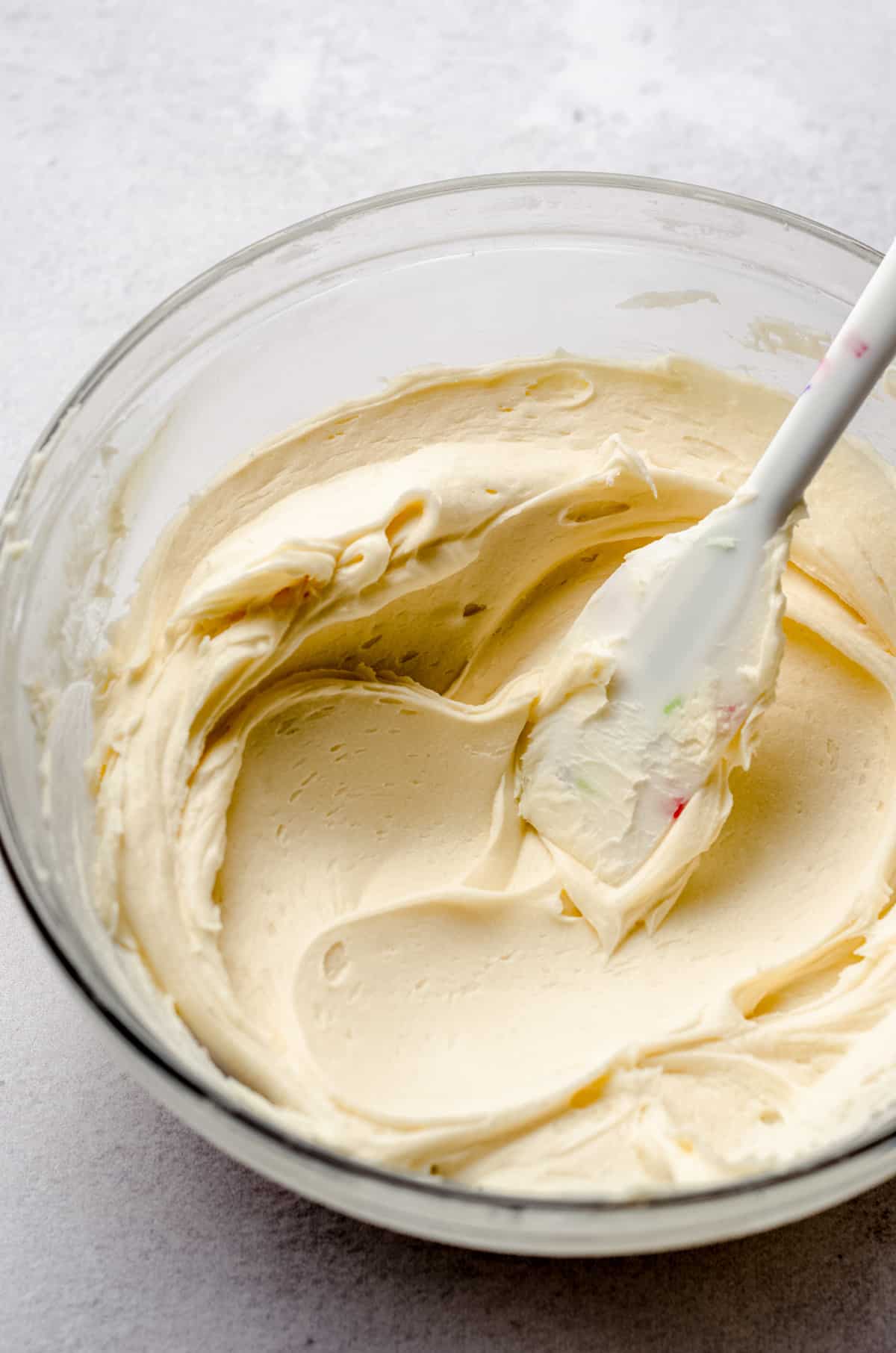 bowl of vanilla buttercream frosting with a spatula