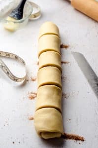 A log of small batch cinnamon roll dough sliced into 6 slices.