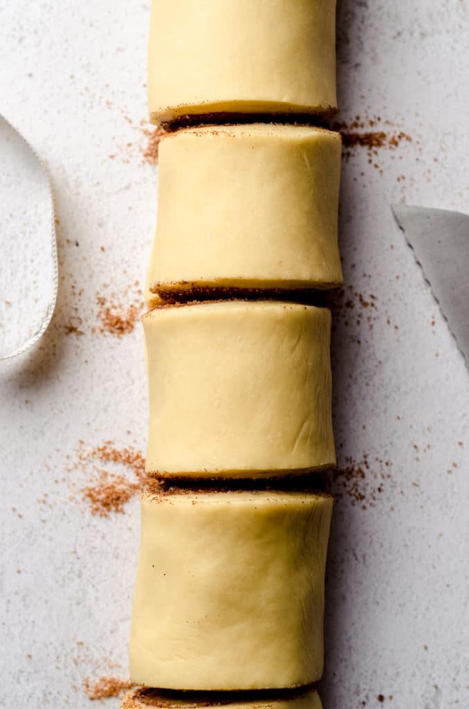 A closeup of sliced cinnamon roll dough.