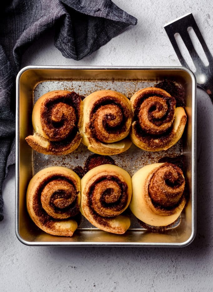 Aerial photo of baked cinnamon rolls in a square baking pan.