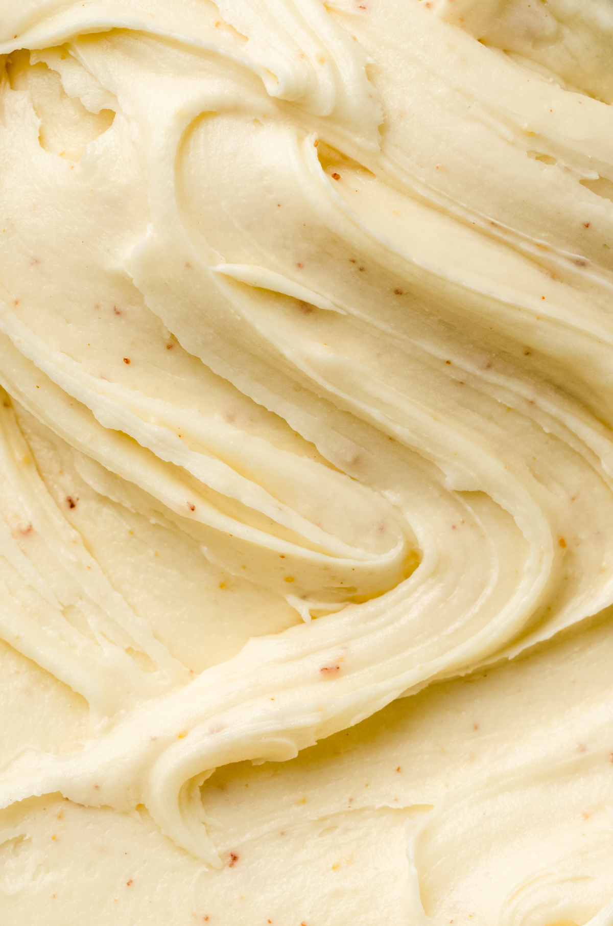 A closeup of a swirl of brown butter cream cheese frosting.