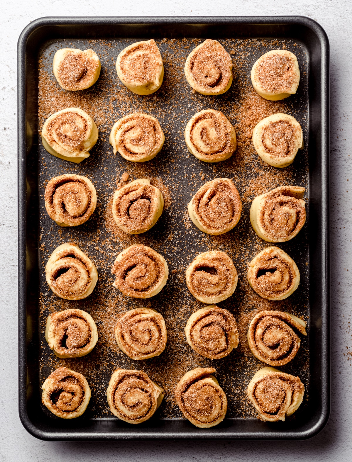 Aerial photo of mini cinnamon rolls in a baking dish after rising.