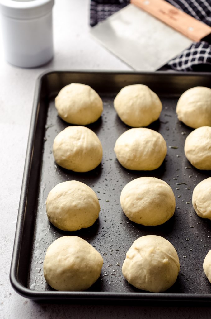 Sourdough roll balls on a baking sheet before rising.