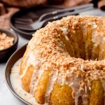coconut bundt cake on a serving dish with forks in the background.