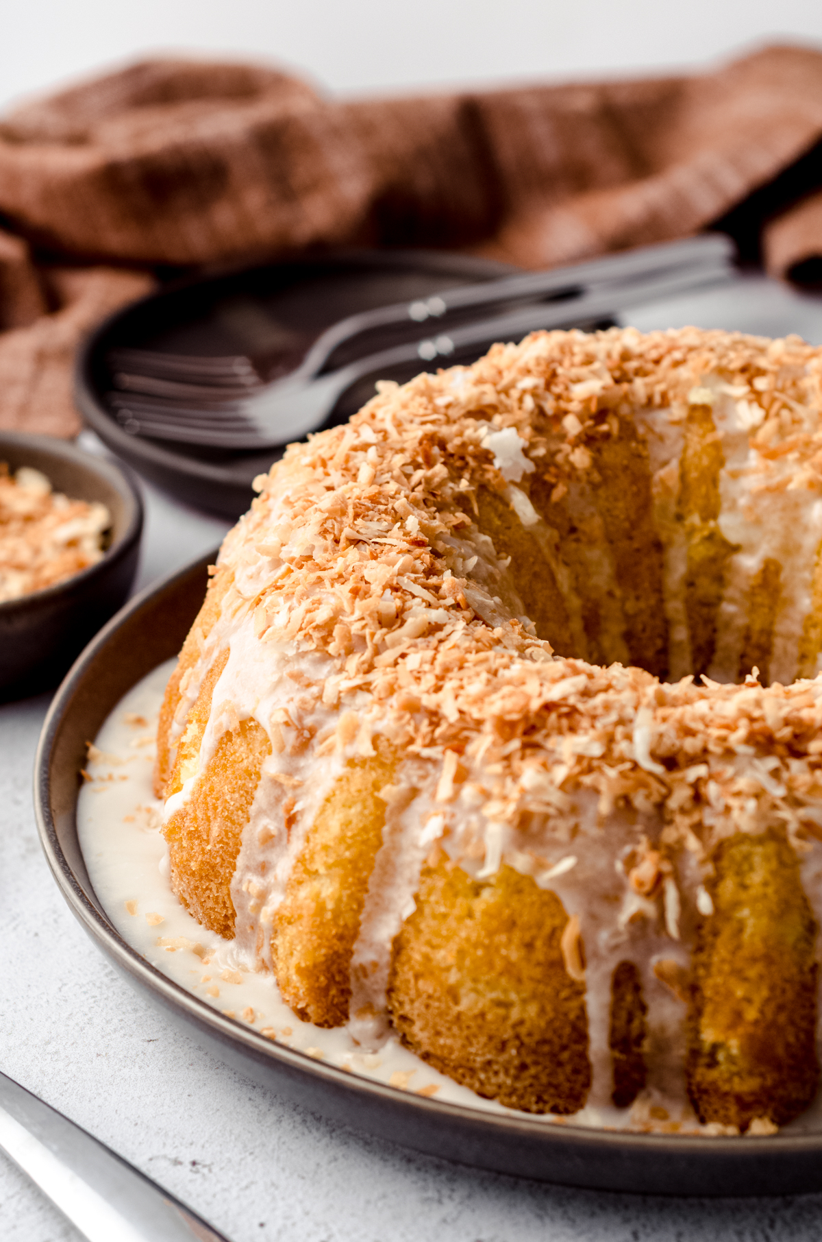 coconut bundt cake on a serving dish with forks in the background.
